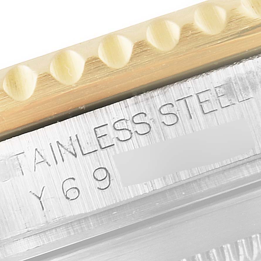 This image is a close-up angle showing the stainless steel and bezel of a Rolex Submariner 16613 Men's Steel and Gold (two tone) Blue Dial 16613 Men's Steel and Gold (two tone) Blue Dial watch with partial engravings.