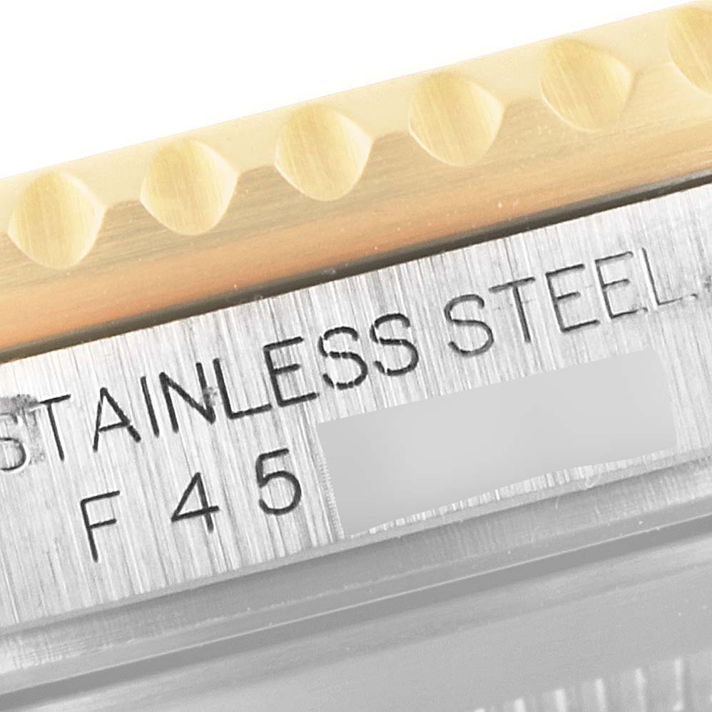 This close-up image shows the edge of the case and bezel with "STAINLESS STEEL" engraving on a Rolex Submariner 16613 Men
s Steel and Gold (two tone) Blue Dial 16613 Men
s Steel and Gold (two tone) Blue Dial watch.