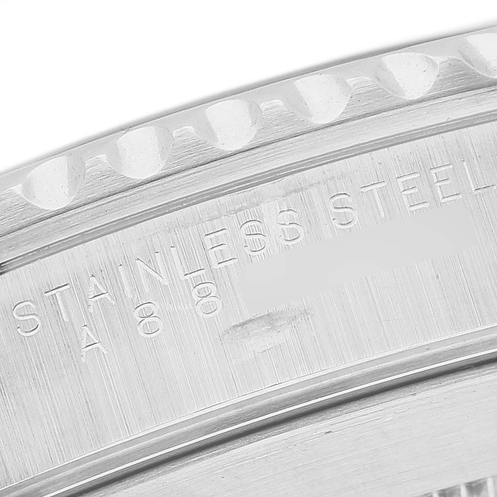 The image shows a close-up of the engraved edge of a Rolex Submariner 14060 Men's Stainless Steel Black Dial watch, focusing on the stainless steel marking.