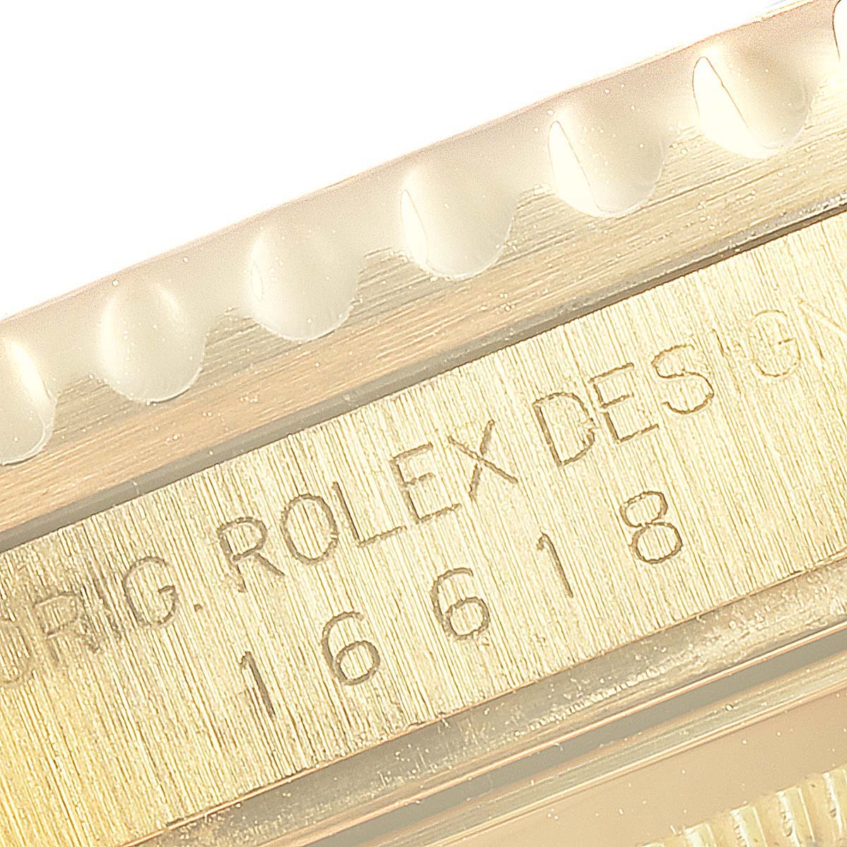 The image shows a close-up of the side engraving on the bezel of the Rolex Submariner 16618 Men's Yellow Gold Blue Dial 16618 Men's Yellow Gold Blue Dial model 16618.