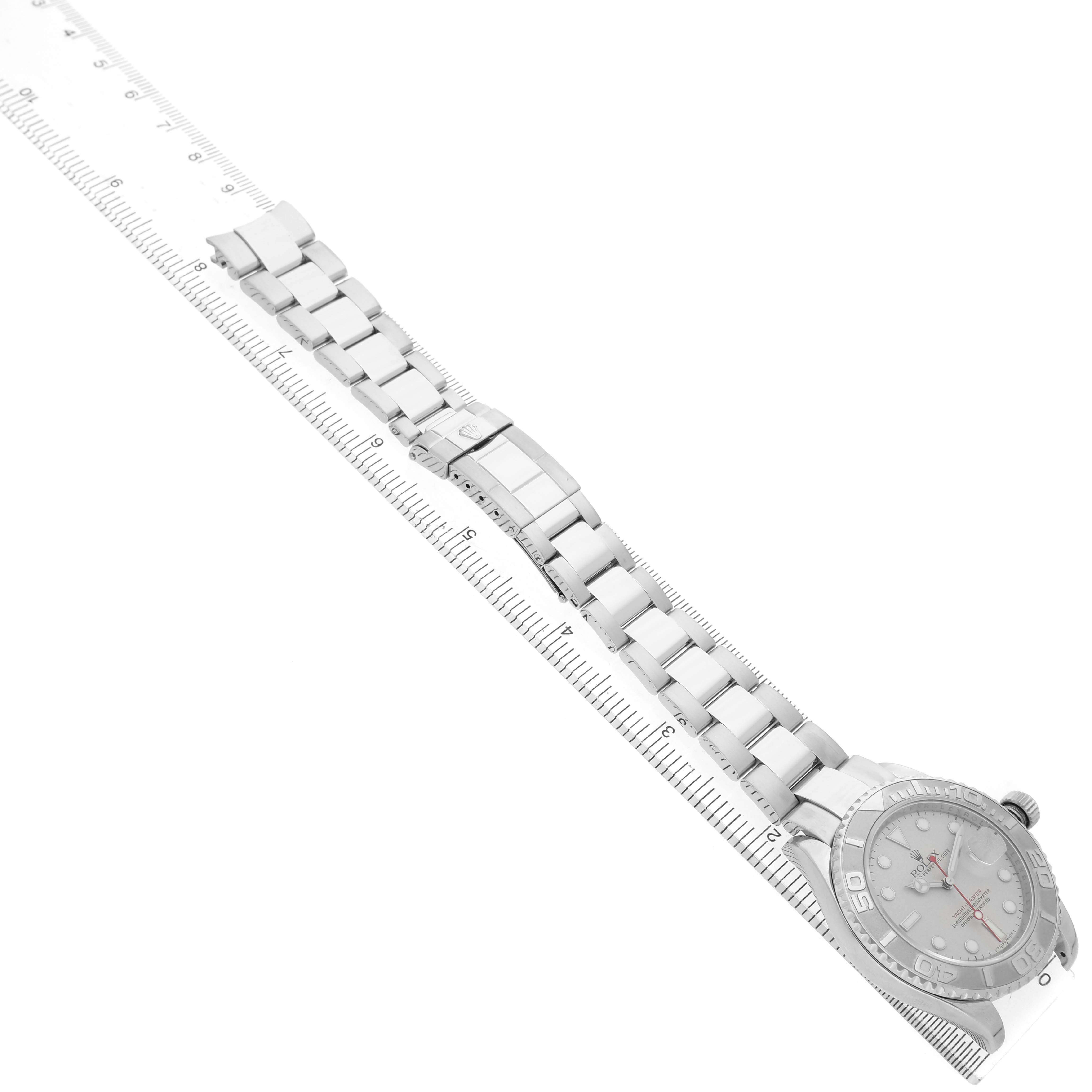 The Rolex Yacht-Master 16622 Men's Stainless Steel Silver Dial watch is shown diagonally, highlighting the face, bezel, and bracelet alongside a ruler.