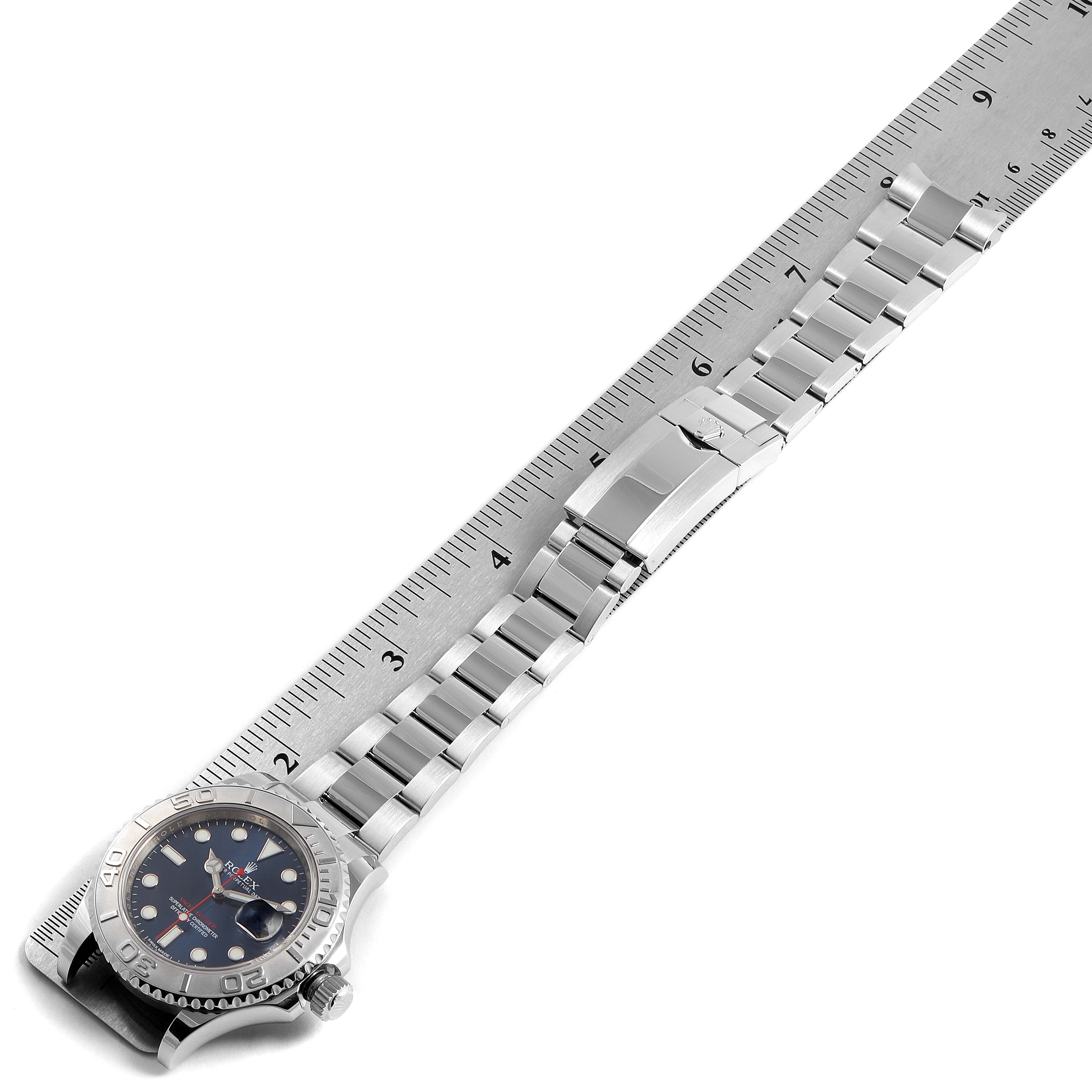 The Rolex Yacht-Master 116622 Men
s Stainless Steel Blue Dial 116622 Men
s Stainless Steel Blue Dial watch is shown from a top angle, highlighting the dial, bezel, bracelet, and clasp alongside a ruler.
