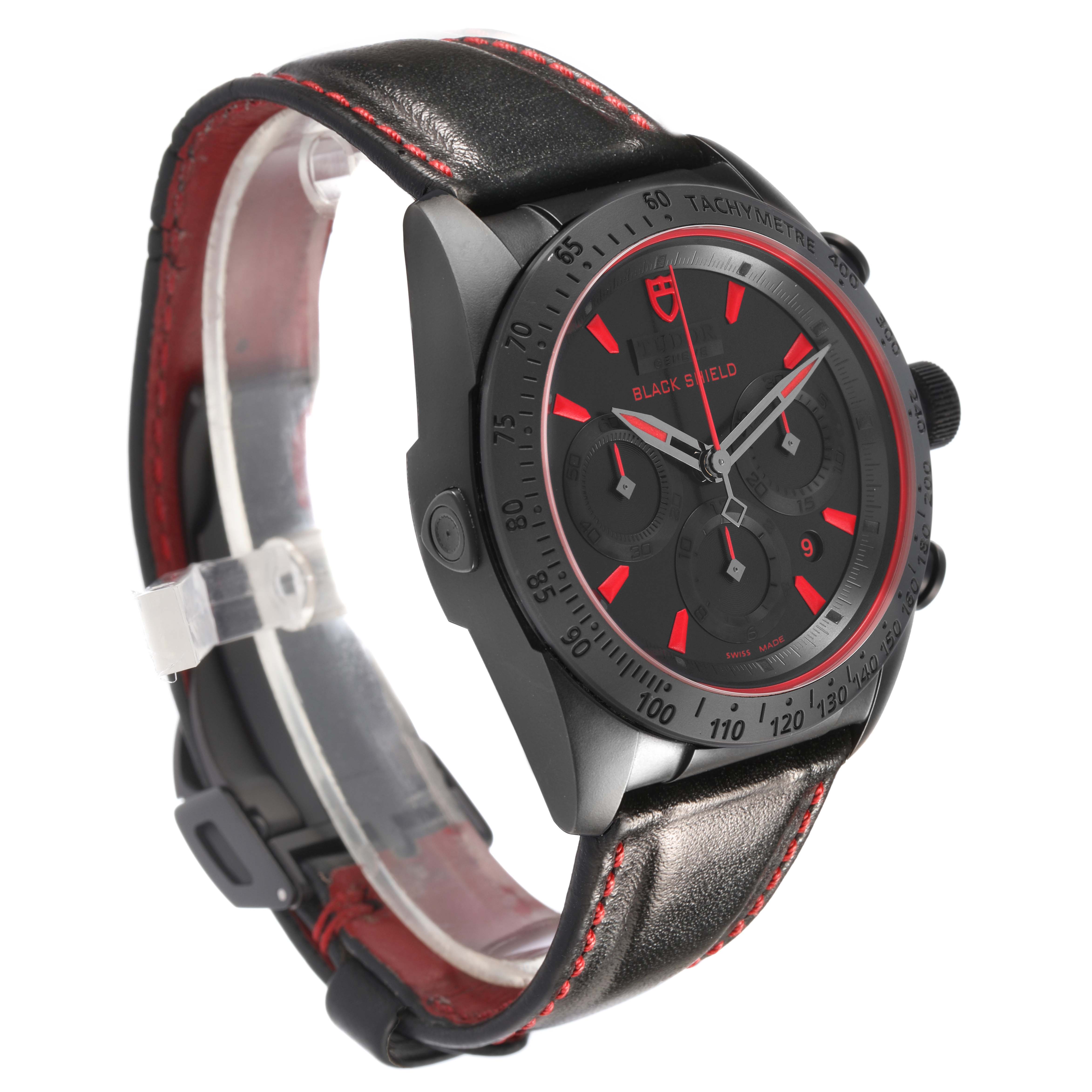 The Tudor Fastrider 42000CR Men's Ceramic Black Dial watch is shown at a three-quarter angle, highlighting its black case, tachymeter bezel, and leather strap with red stitching.