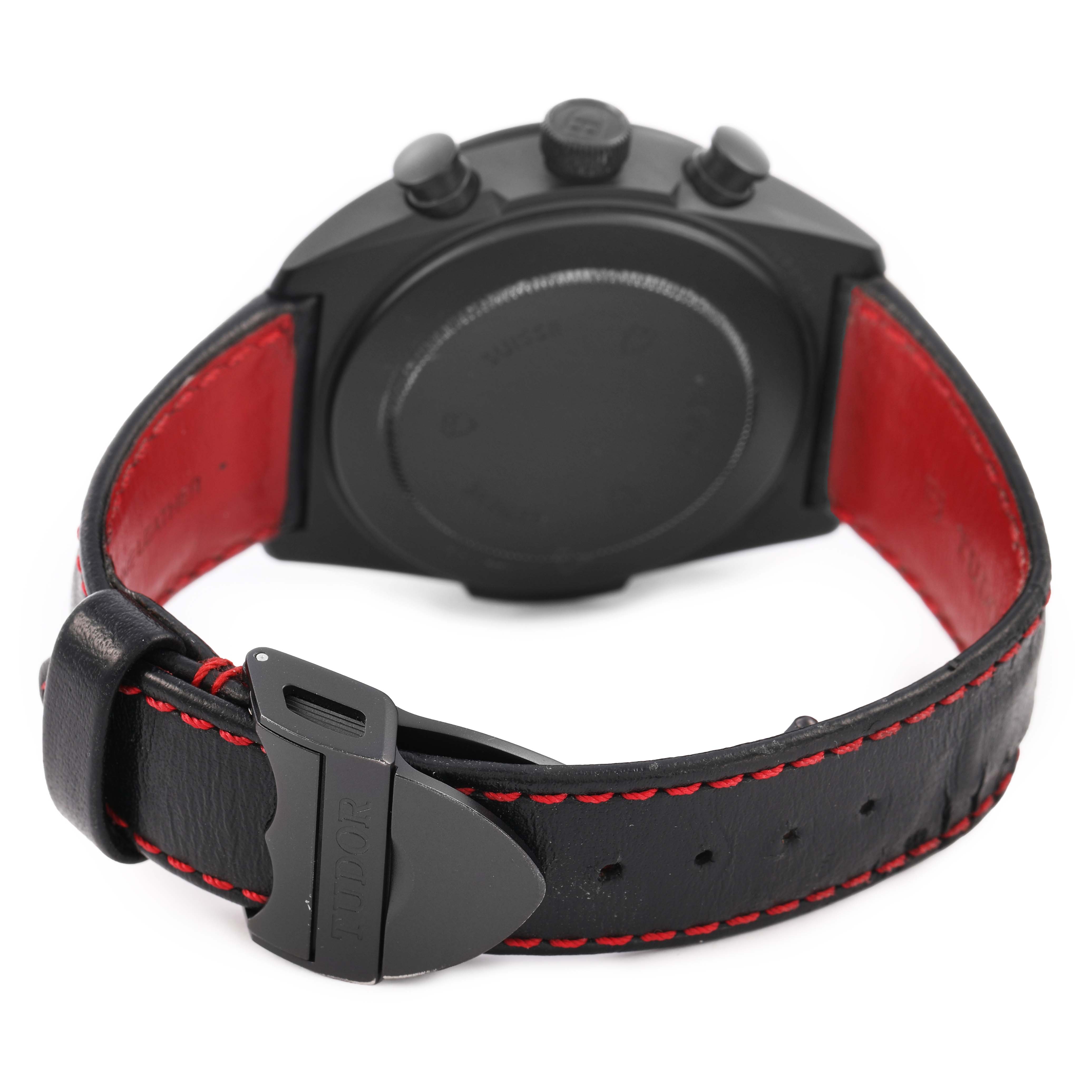 The image shows the Tudor Fastrider 42000CR Men's Ceramic Black Dial watch from the back, highlighting the case, crown, pushers, and leather strap with red stitching.