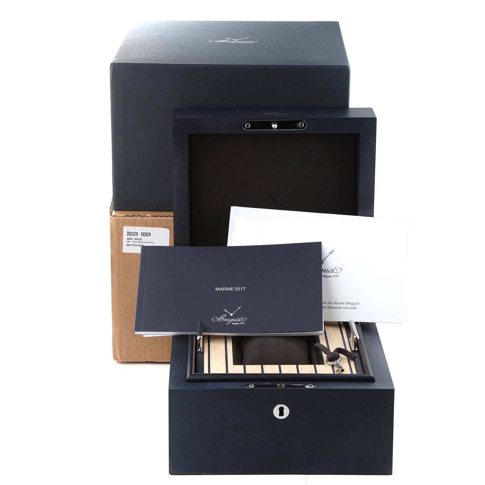 The image shows the packaging, instruction manuals, and a wooden box for the Breguet Marine 5517TI/Y1/5ZU Men's Titanium Blue Dial 5517TI/Y1/5ZU Men's Titanium Blue Dial model watch.