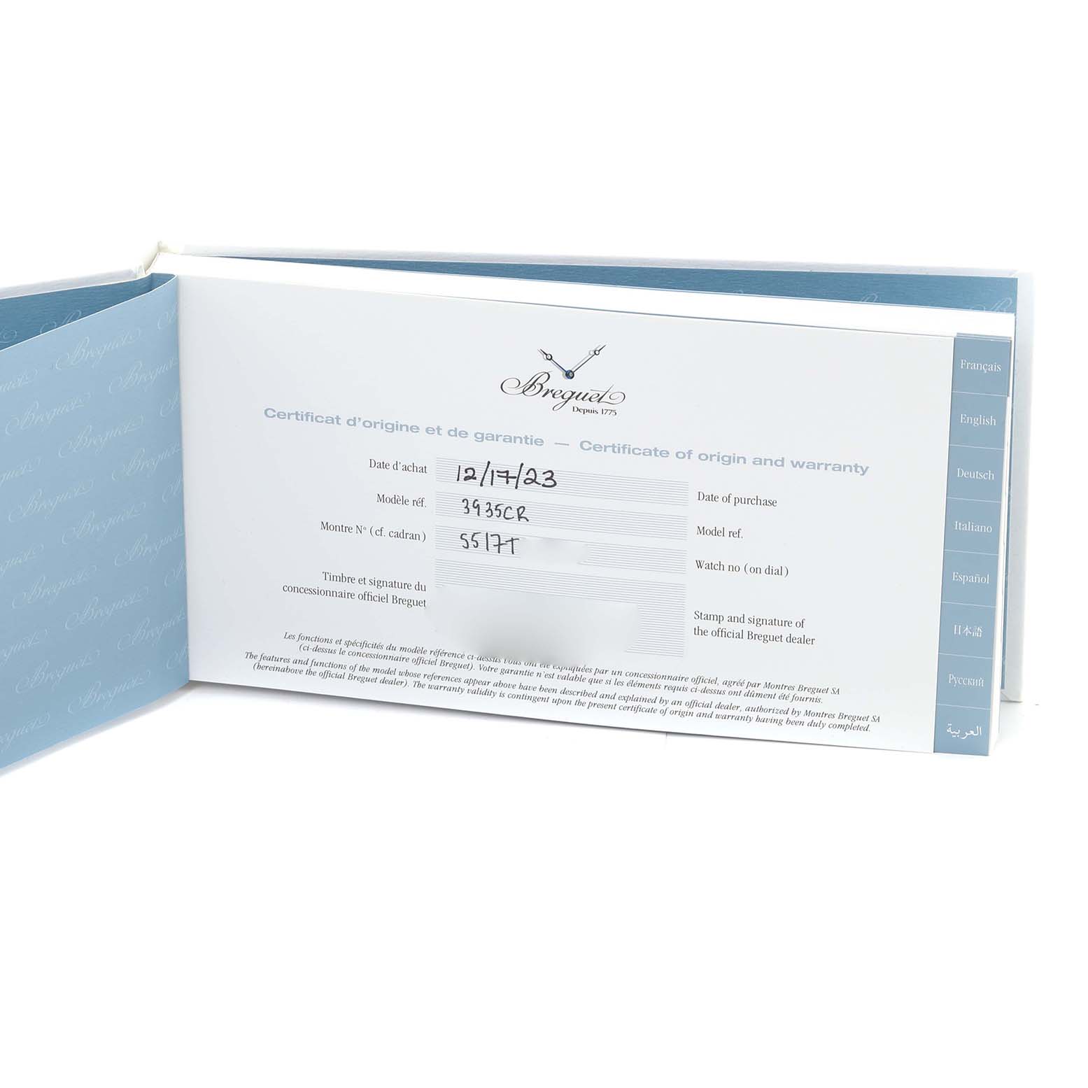 The image shows the warranty and certificate of origin booklet for a Breguet Marine 5517TI/Y1/5ZU Men's Titanium Blue Dial 5517TI/Y1/5ZU Men's Titanium Blue Dial model watch, placed at an angled view.