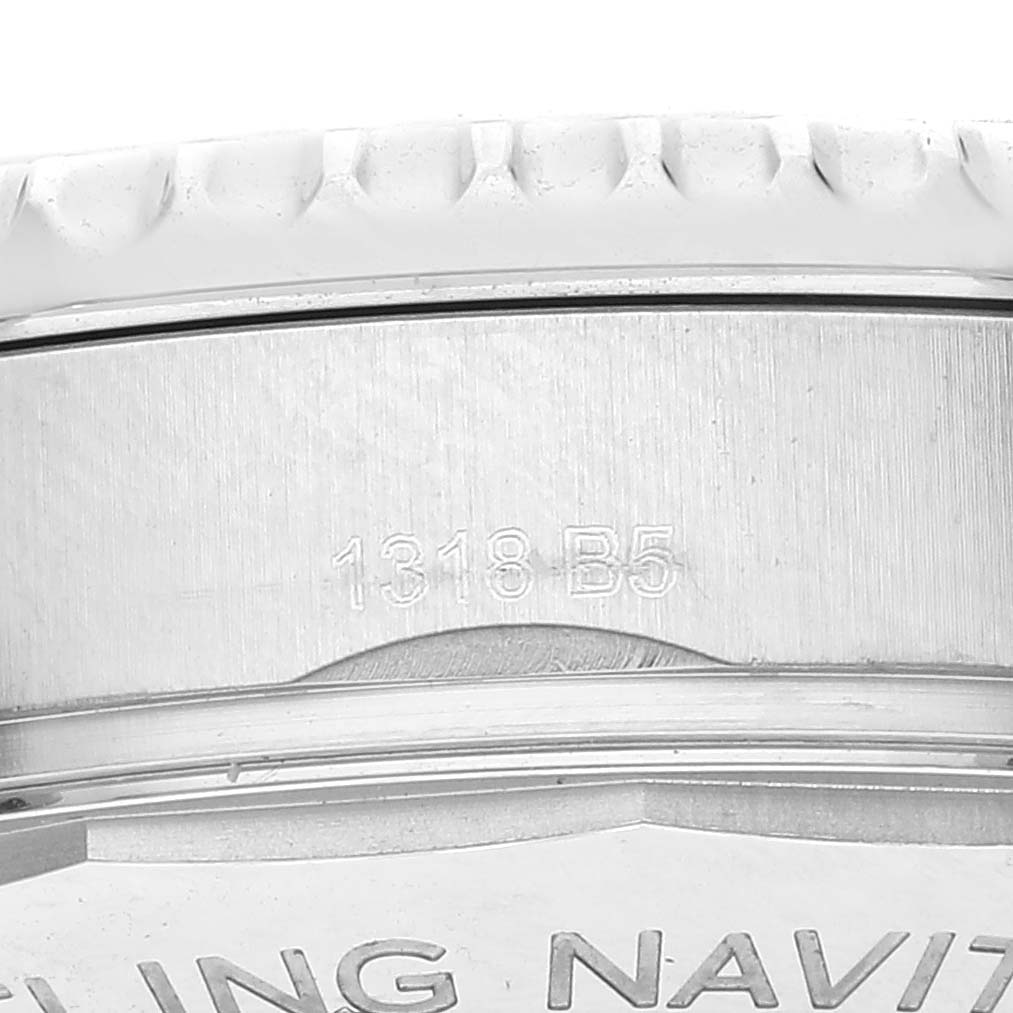 The image shows a close-up view of the bezel and edge of the case back of a Breitling Navitimer watch, with engraving visible.
