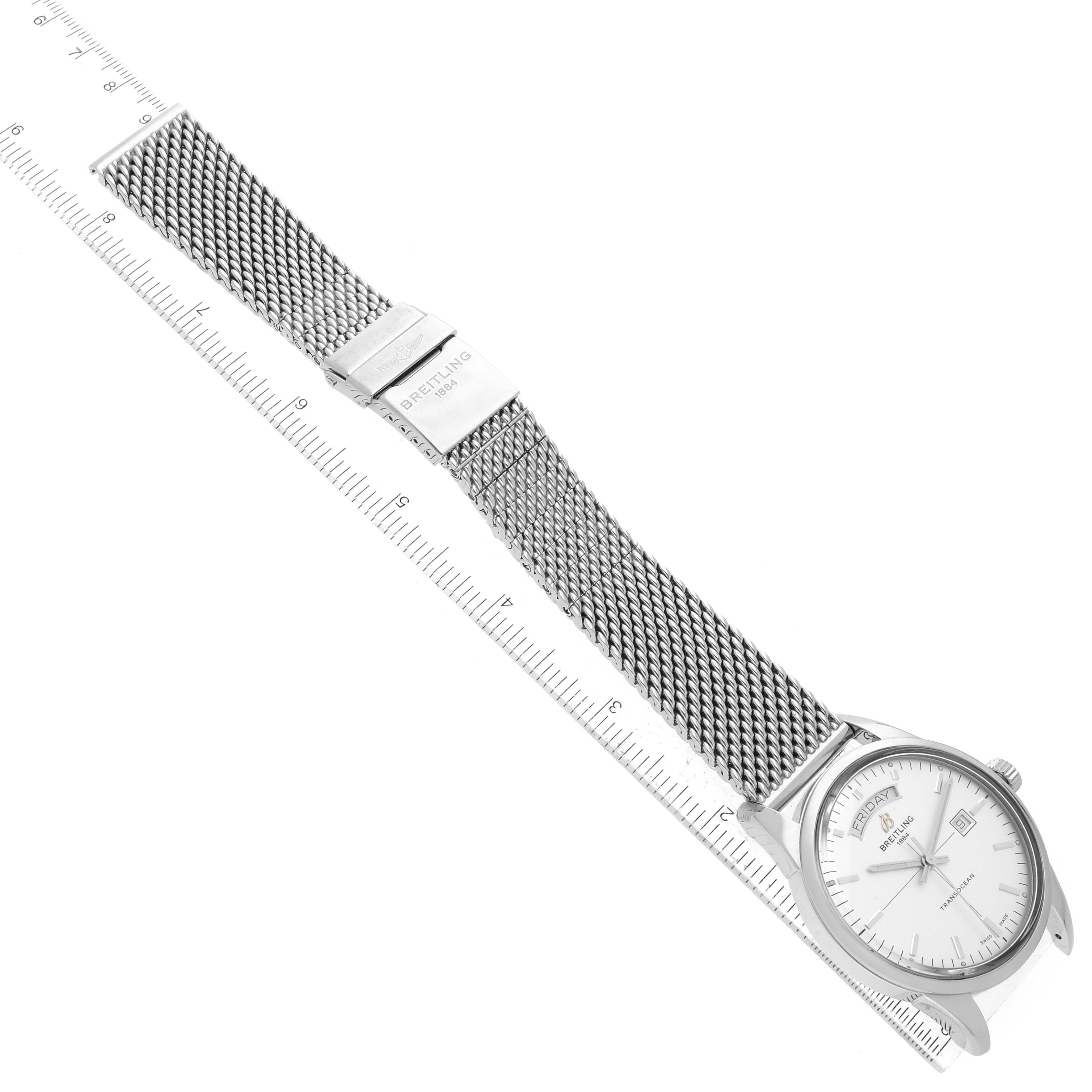 The image shows a Breitling Transocean A45310 Men
s Stainless Steel White Dial A45310 Men
s Stainless Steel White Dial watch laying flat, displaying its mesh strap, clasp, and face alongside a ruler for scale.
