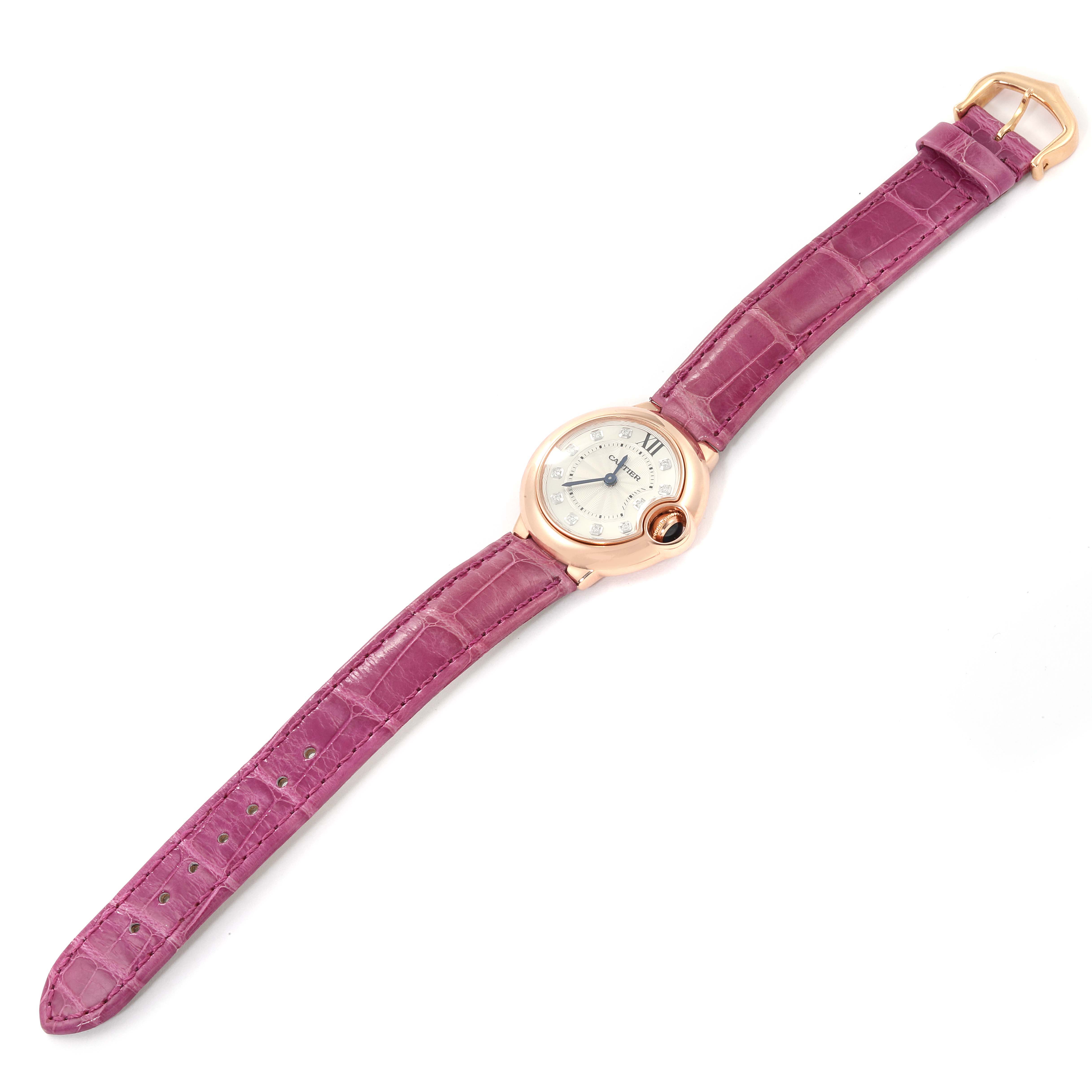 The image shows an overhead view of a Cartier Ballon Bleu WE902050 Women
s Rose Gold Silver Dial WE902050 Women
s Rose Gold Silver Dial watch with a purple leather strap and rose gold case.