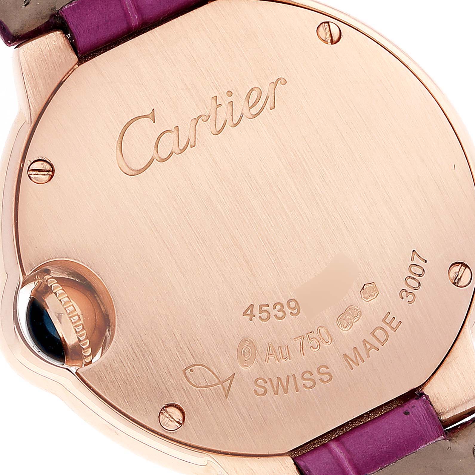 The image shows the back of a Ballon Bleu model by Cartier, displaying the brand name, serial number, and other engravings.