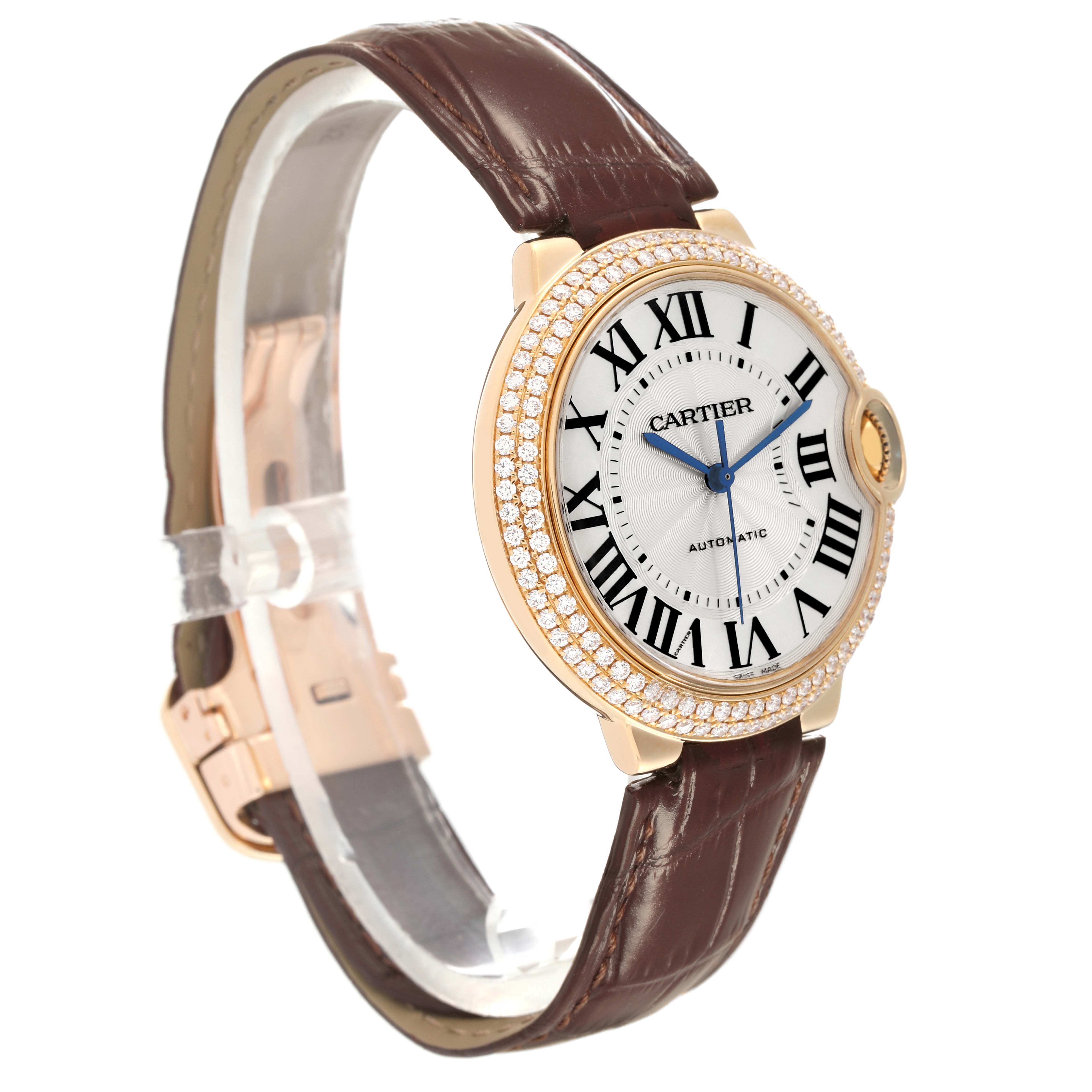 The Ballon Bleu de Cartier watch is shown at a slight angle, featuring the face, bezel with diamonds, and brown leather strap.