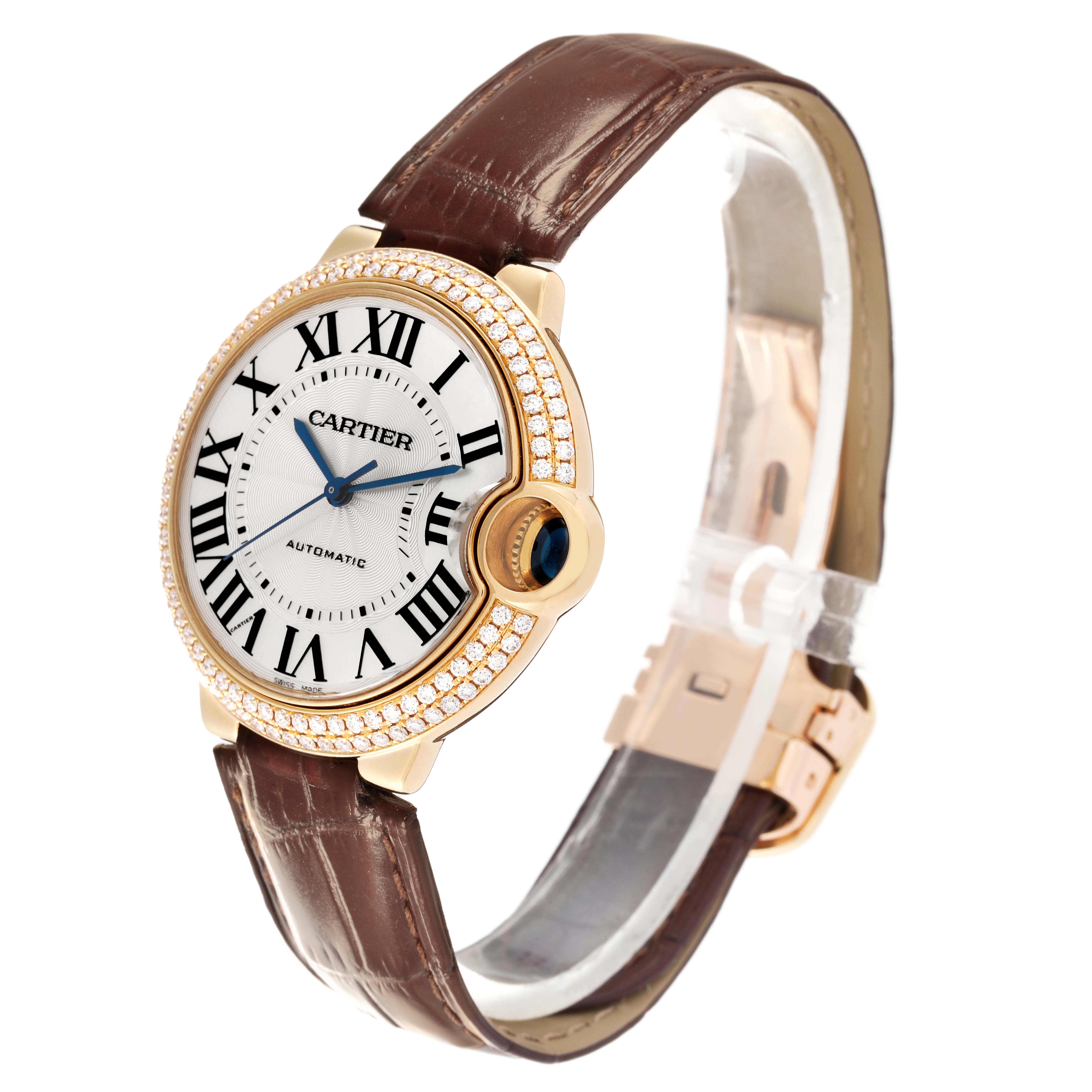 The Cartier Ballon Bleu WE900451 Men's Yellow Gold Silver Dial WE900451 Men's Yellow Gold Silver Dial watch is shown from a three-quarter angle, highlighting its face, bezel, and brown leather strap.