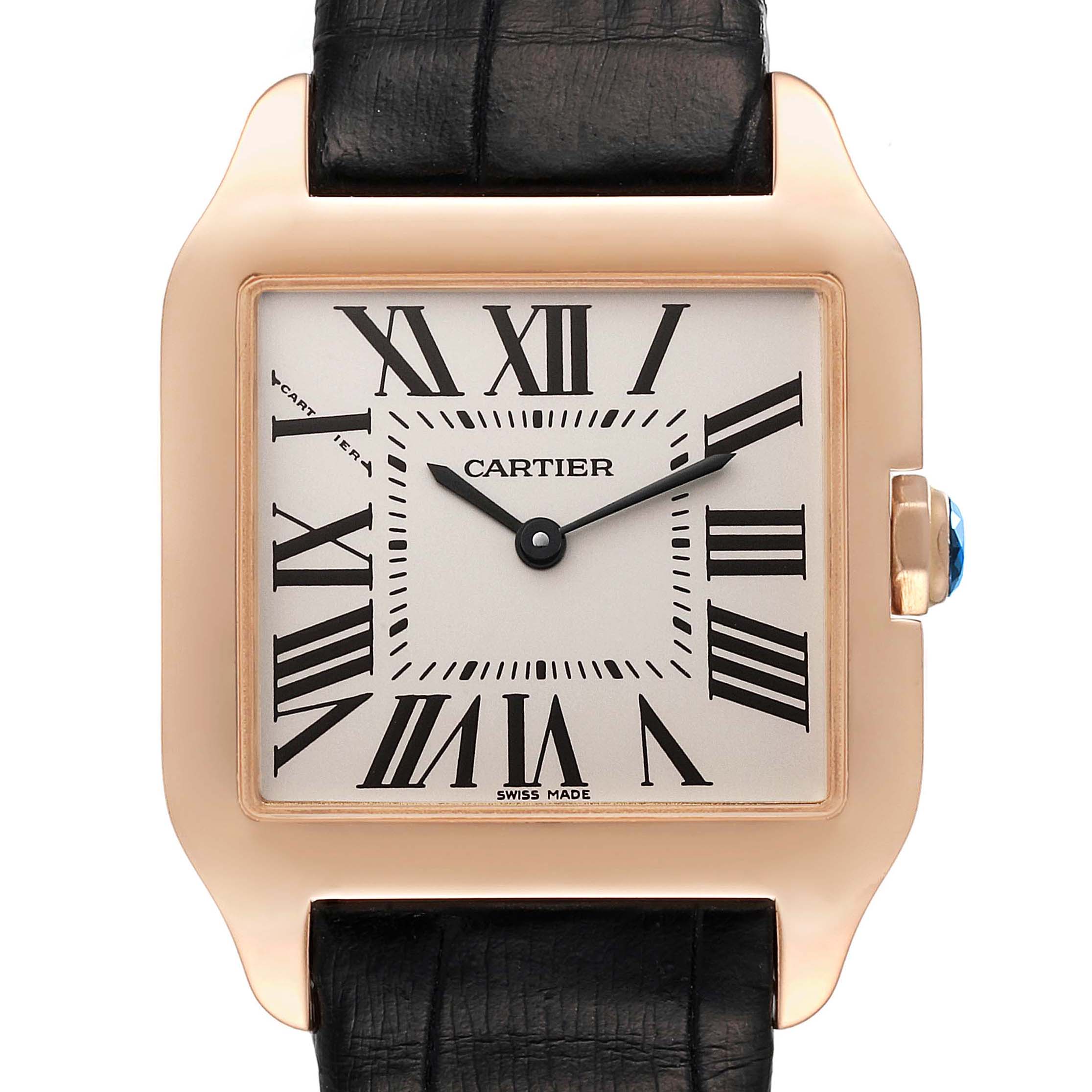 The image shows a front view of a Cartier Santos Dumont W2009251 Men's Rose Gold Silver Dial W2009251 Men's Rose Gold Silver Dial watch, highlighting its face, hands, Roman numerals, black strap, and crown with a blue stone.
