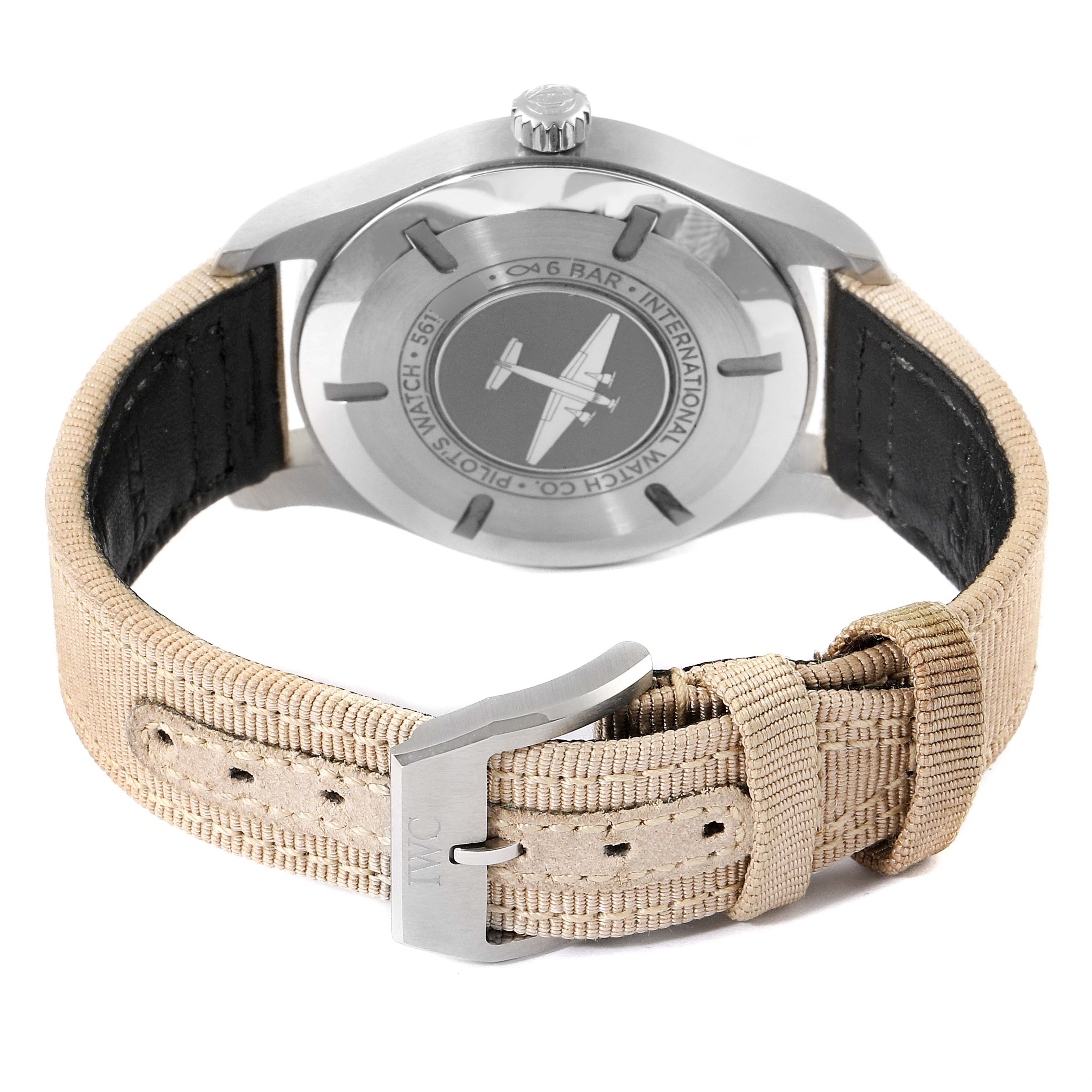 The image shows the back view of an IWC Pilot IW327017 Men's Stainless Steel Silver Dial IW327017 Men's Stainless Steel Silver Dial model watch, highlighting the case back engraving and beige strap with a metal clasp.