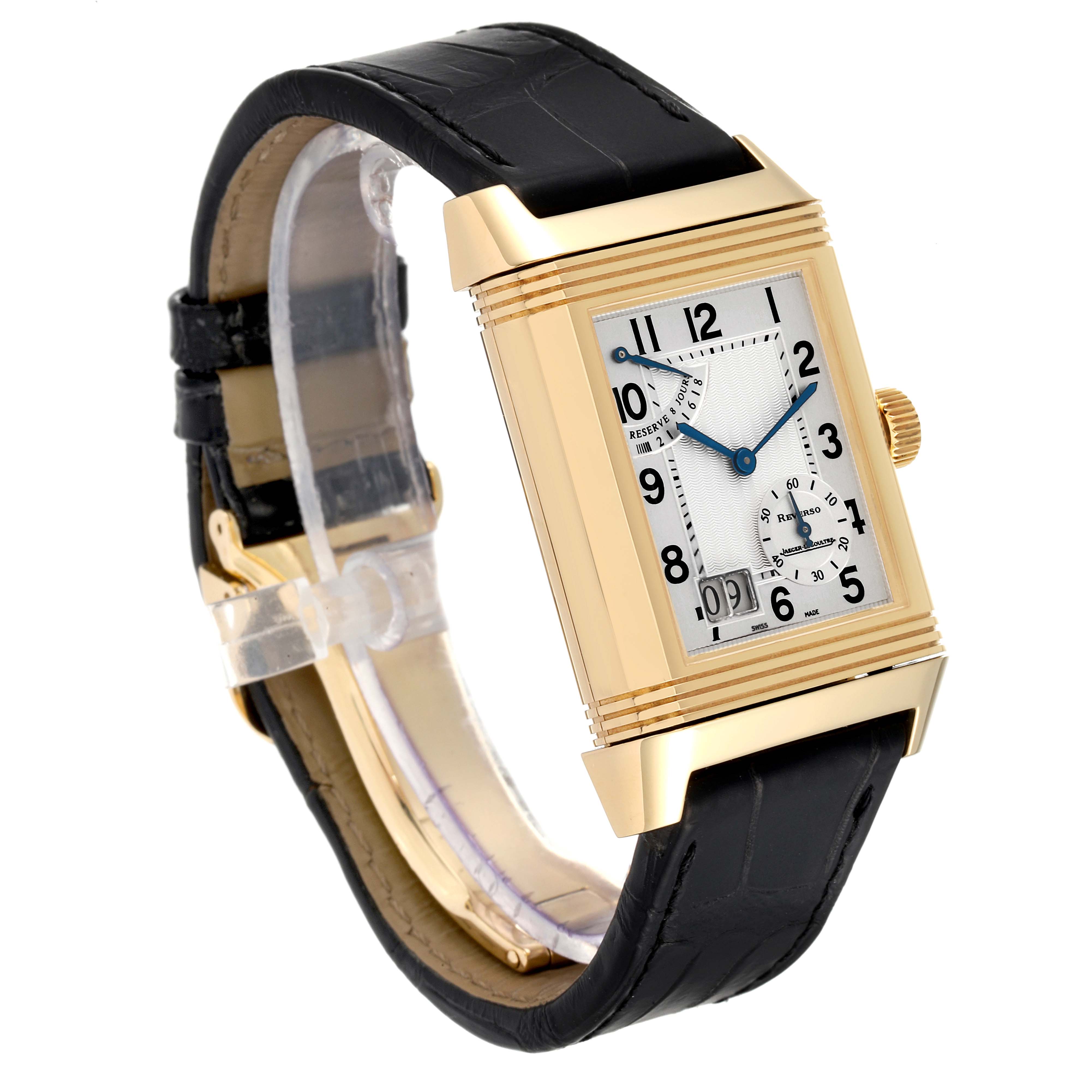 The Jaeger-LeCoultre Reverso watch is shown at a three-quarter angle, displaying its gold case, black leather strap, and rectangular dial.