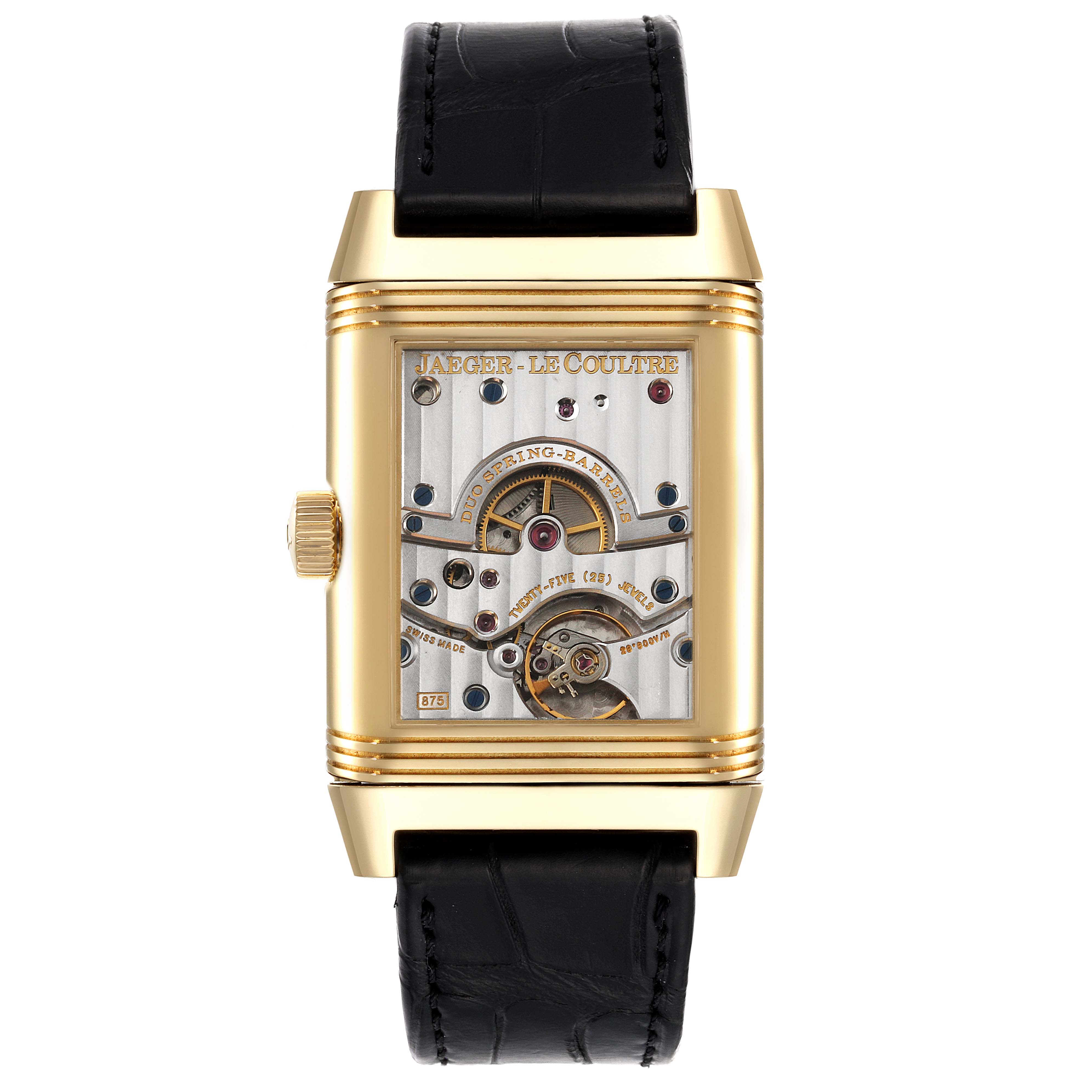The image shows the back view of a Jaeger-LeCoultre Reverso watch, displaying its intricate movement and parts.
