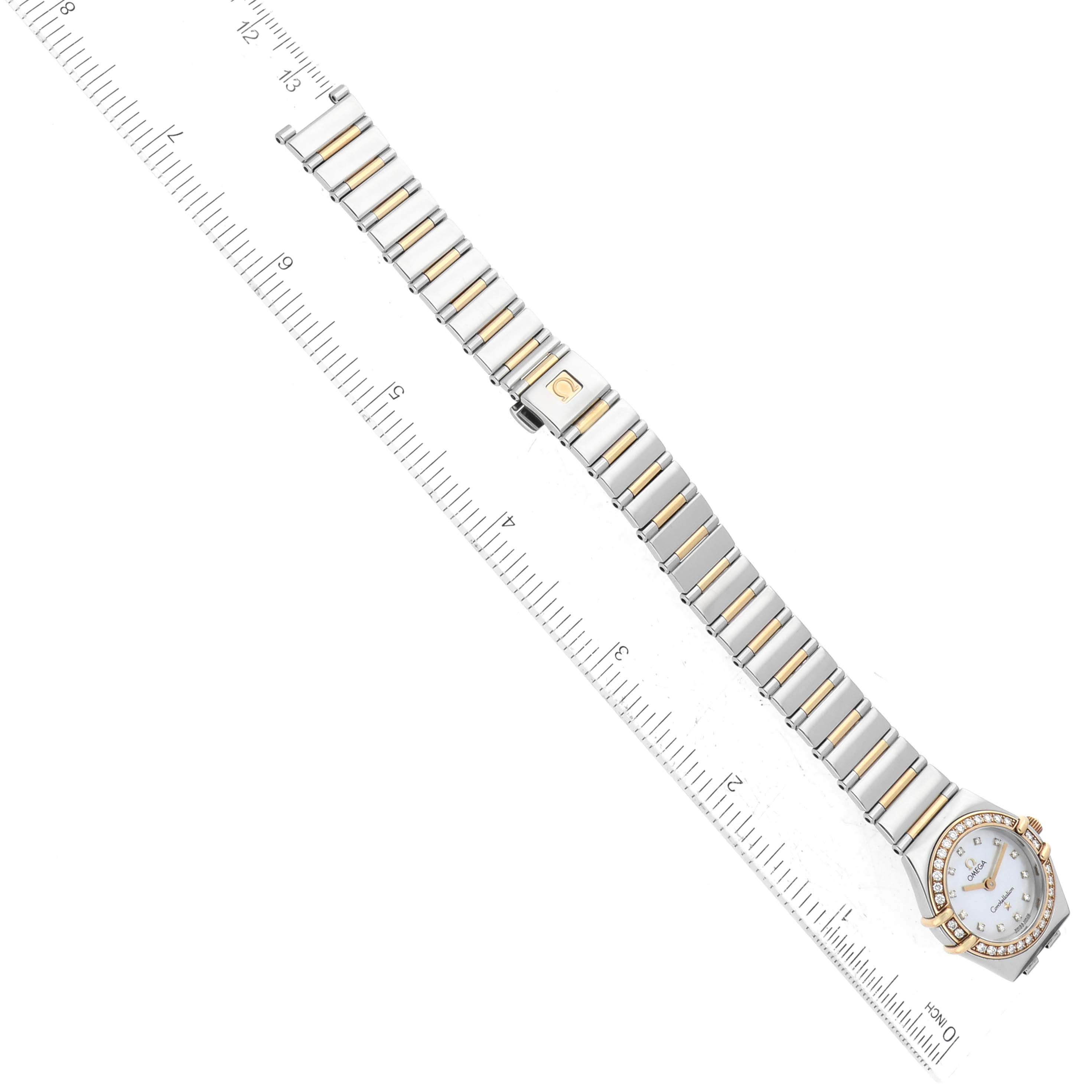 The Omega 1267.75.00 Women's Steel and Gold (two tone) Mother of Pearl Dial 1267.75.00 Women's Steel and Gold (two tone) Mother of Pearl Dial Constellation 95 Mother of Pearl Diamond Yellow Gold Steel Ladies Watch 1267.75.00 is displayed from a top-down angle alongside a ruler.