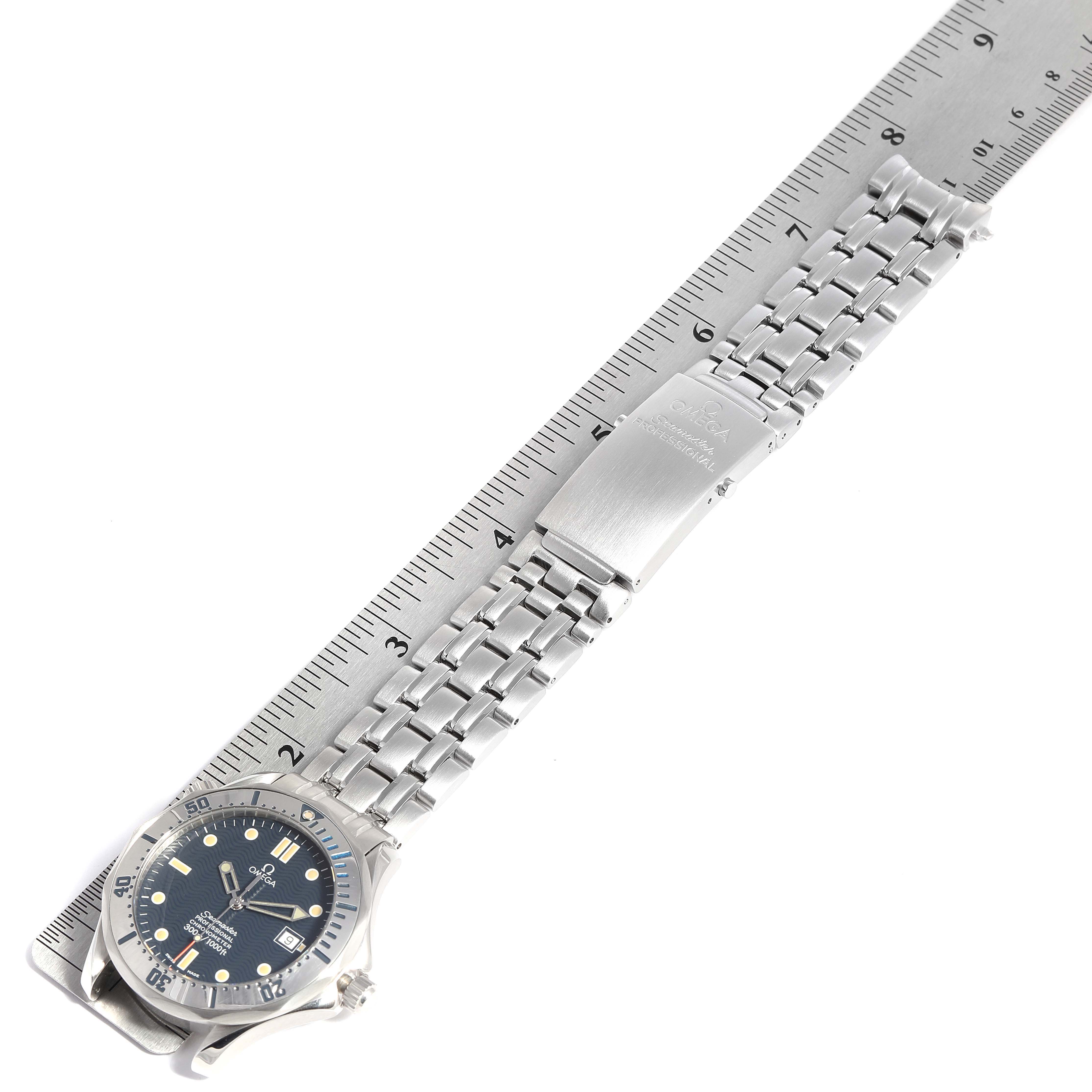 The Omega Seamaster 2532.80.00 Men's Stainless Steel Blue Dial 2532.80.00 Men's Stainless Steel Blue Dial watch is shown laying flat, revealing the face, bezel, stainless steel bracelet, and clasp alongside a ruler.