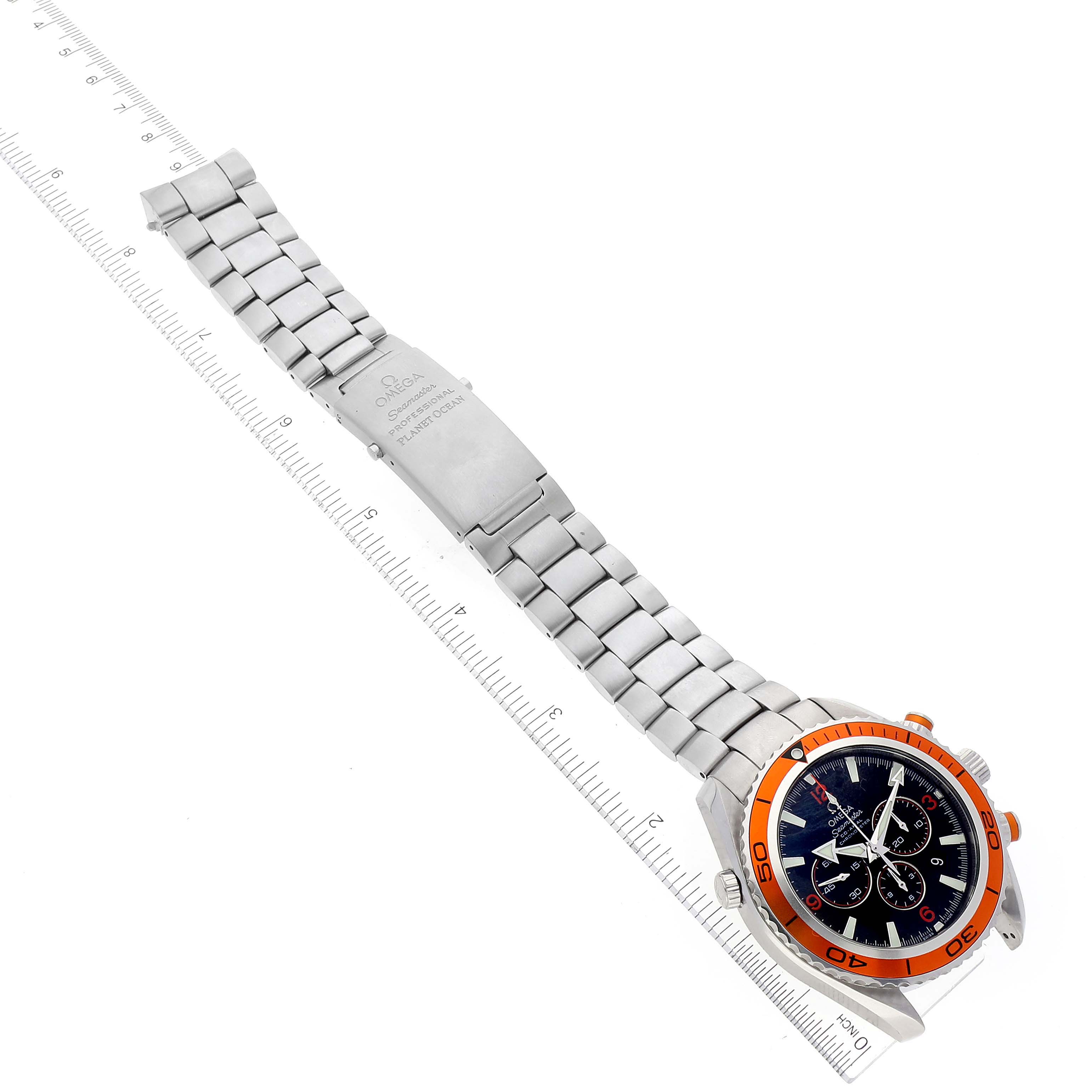 The image shows the Omega Planet Ocean 2218.50.00 Men
s Stainless Steel Black Dial 2218.50.00 Men
s Stainless Steel Black Dial watch with its stainless steel bracelet and orange bezel, displayed at a diagonal angle.