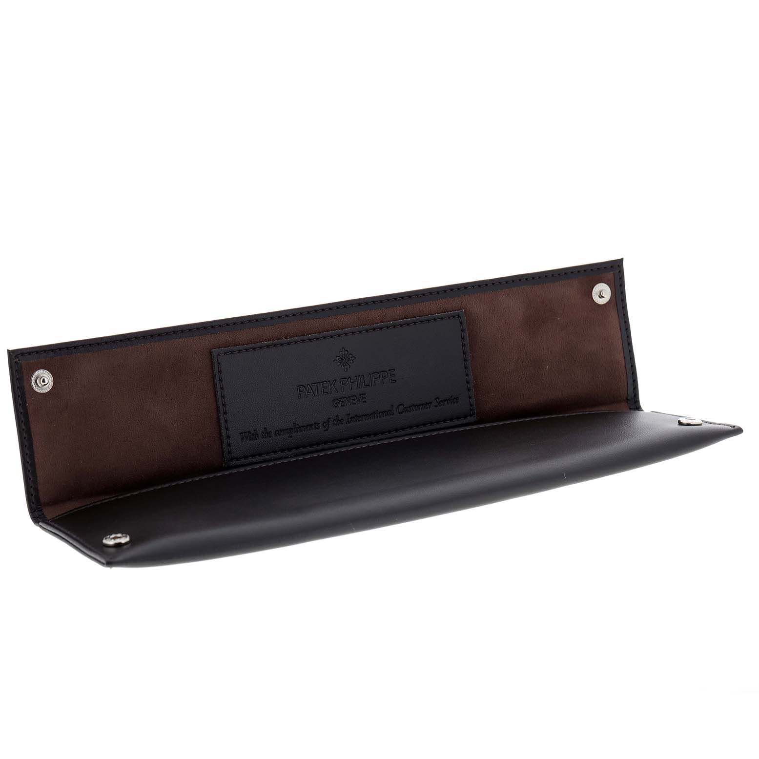 This image features a vintage Patek Philippe watch case with its interior and brand logo displayed.