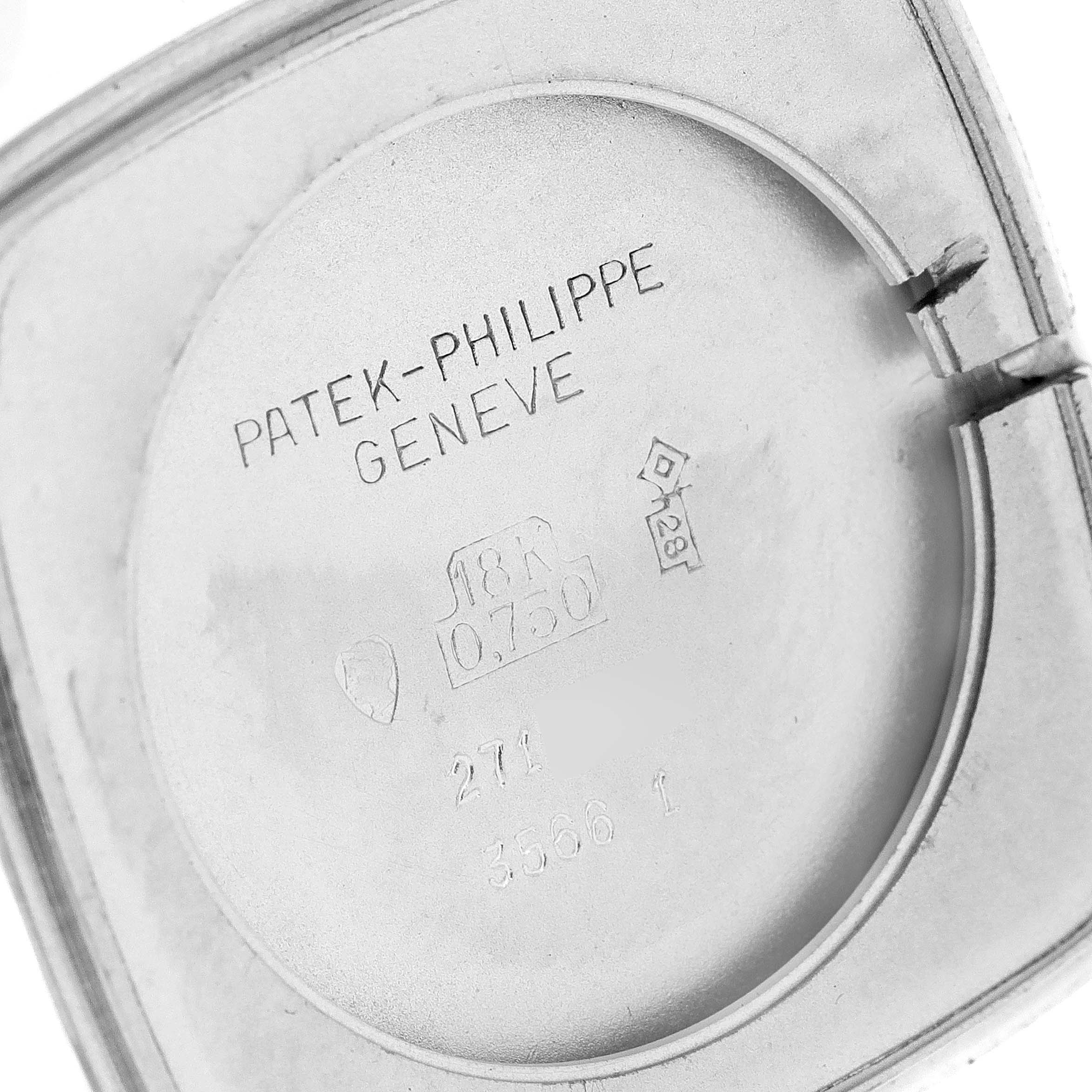 The image shows a close-up of the inner case back of a Vintage Patek Philippe watch, displaying brand engravings and hallmarks.