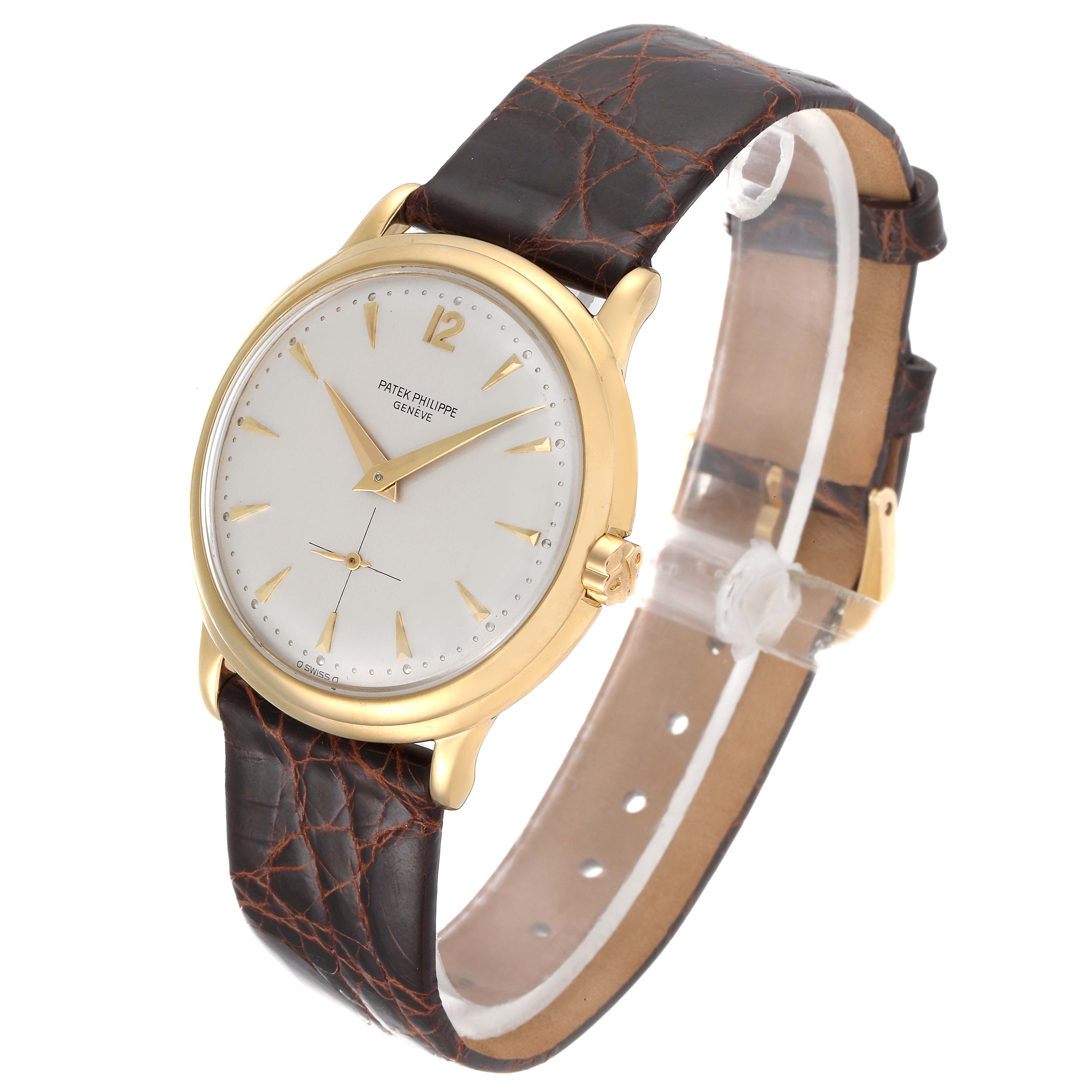 The image shows a Vintage Patek Philippe watch at a slight angle, displaying its gold case, white dial, and brown leather strap.