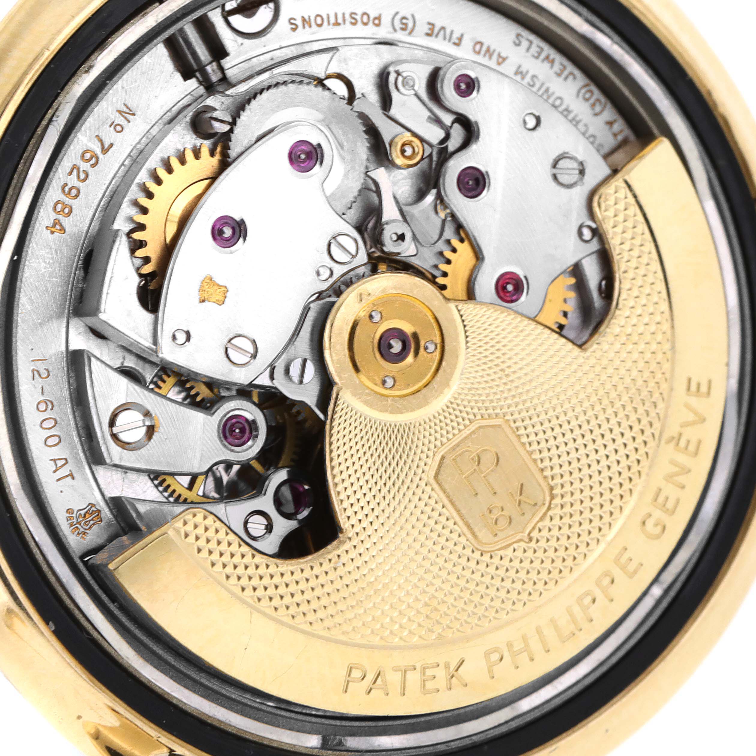 This image shows the intricate internal mechanics of a Vintage Patek Philippe watch, showcasing gears and the engraved rotor.