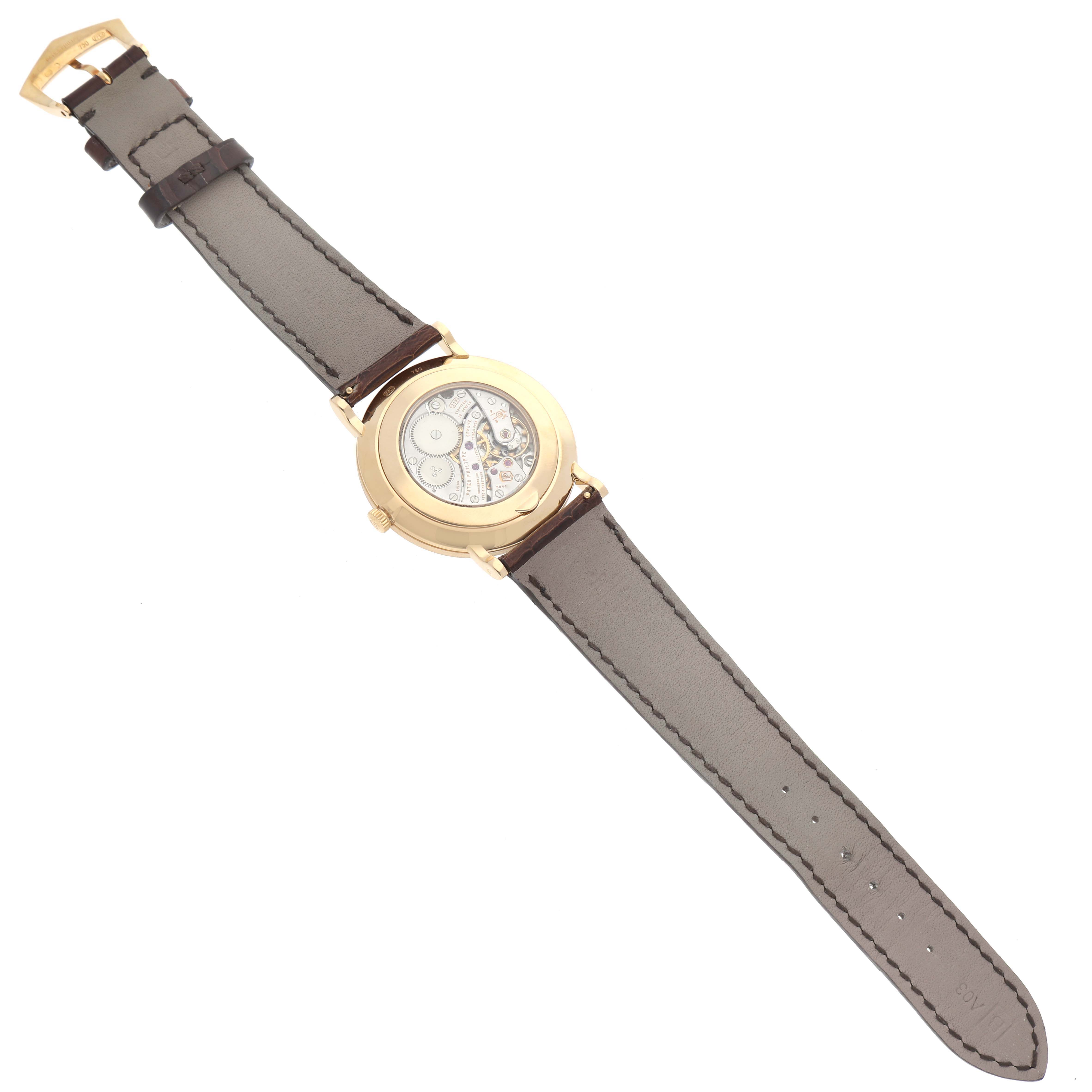 The image shows the back view of a Patek Philippe Calatrava 5119J-001 Men's Yellow Gold White Dial 5119J-001 Men's Yellow Gold White Dial watch, highlighting its transparent case back and leather strap.