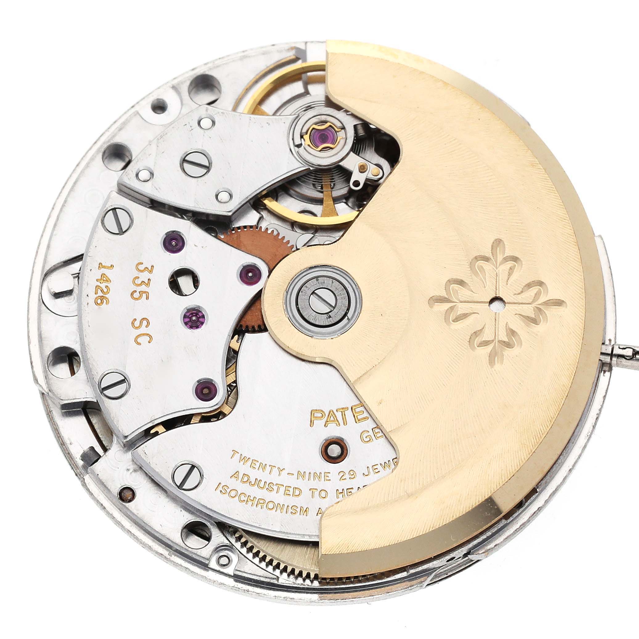This image shows a close-up of the movement mechanism of a Patek Philippe Nautilus 3800/1J Men's Yellow Gold White Dial 3800/1J Men's Yellow Gold White Dial watch, highlighting gears, screws, and engravings.