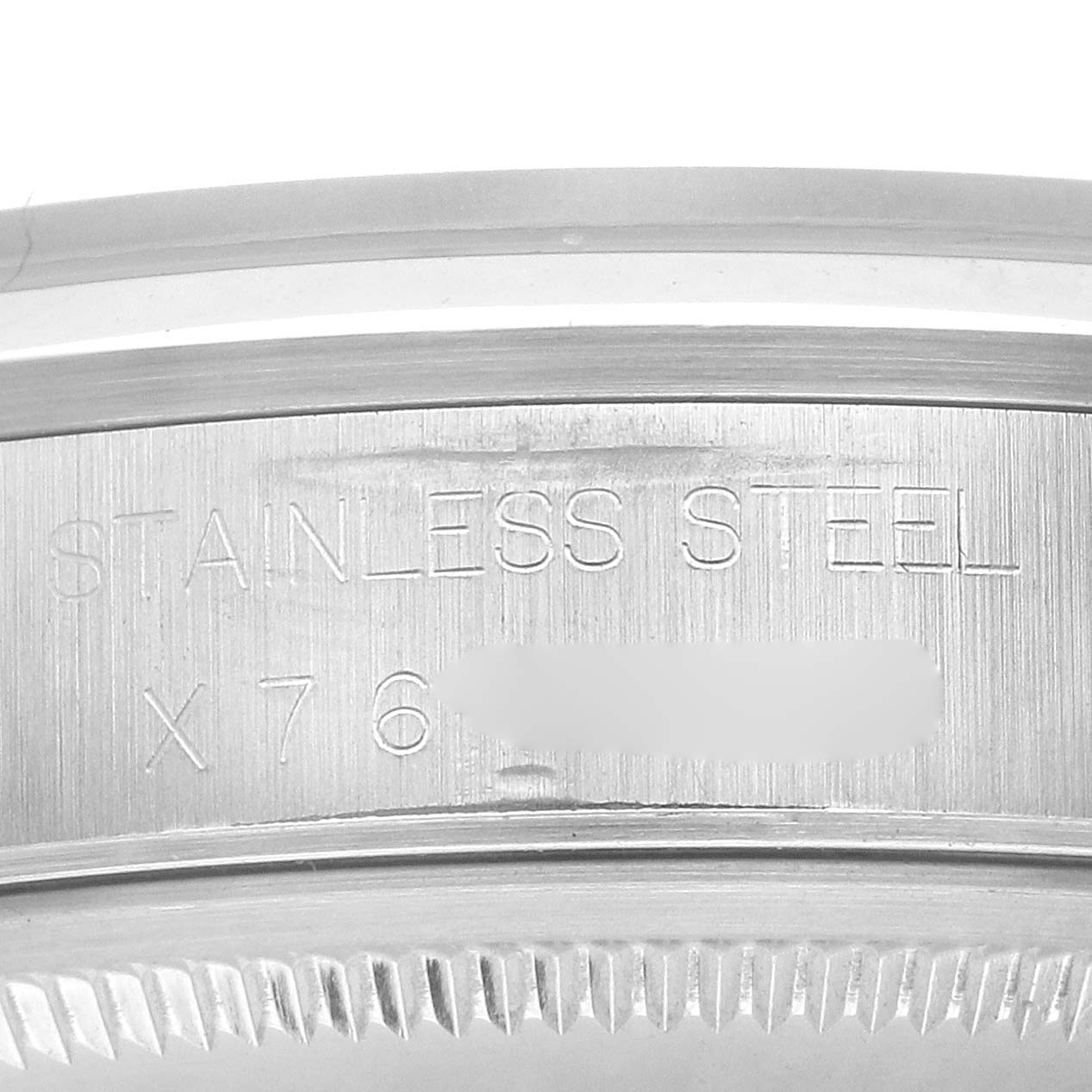 The image shows a close-up of the edge with engraving "STAINLESS STEEL" on a Rolex Air-King 14000 Men's Stainless Steel Silver Dial watch.