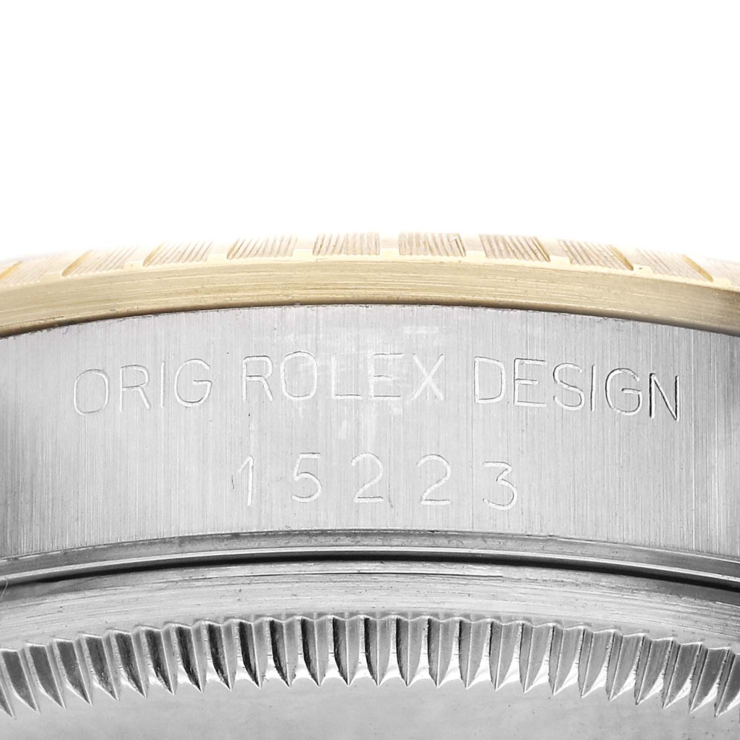 The image shows the side of a Rolex Date 15223 Men's Steel and Gold (two tone) Champagne Dial watch, highlighting the engraved model number and bezel.
