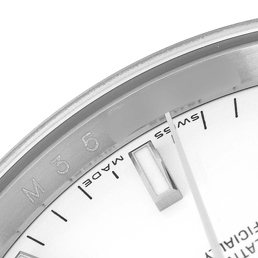 The image shows a close-up angle of the dial, hour markers, and part of the bezel of a Rolex Date 115200 Men's Stainless Steel White Dial 115200 Men's Stainless Steel White Dial model watch.