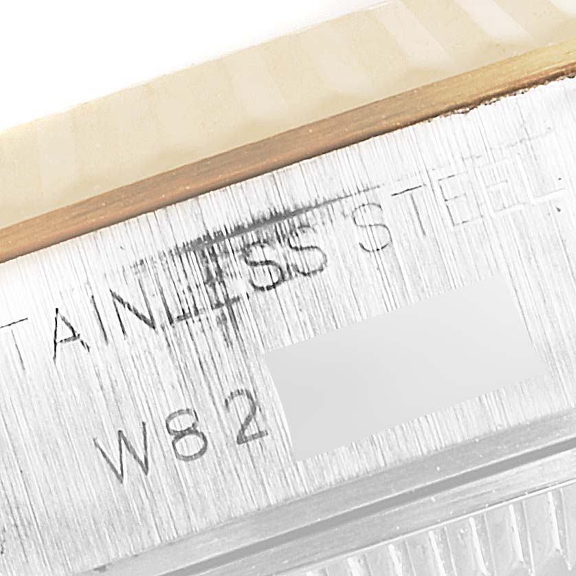 This close-up image of a Rolex Datejust 69173 Women's Steel and Gold (two tone) Champagne Dial 69173 Women's Steel and Gold (two tone) Champagne Dial watch shows part of the bezel and the engraved stainless steel casing with part of the serial number.