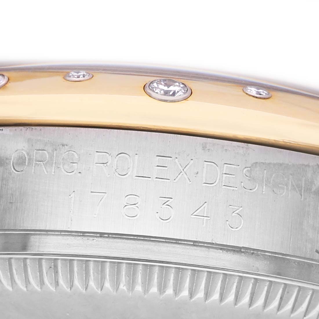 The image shows a close-up of the side of a Rolex Mid-Size 178343 Women's Steel and Gold (two tone) Silver Dial model, highlighting the bezel with gemstones and engraved details.