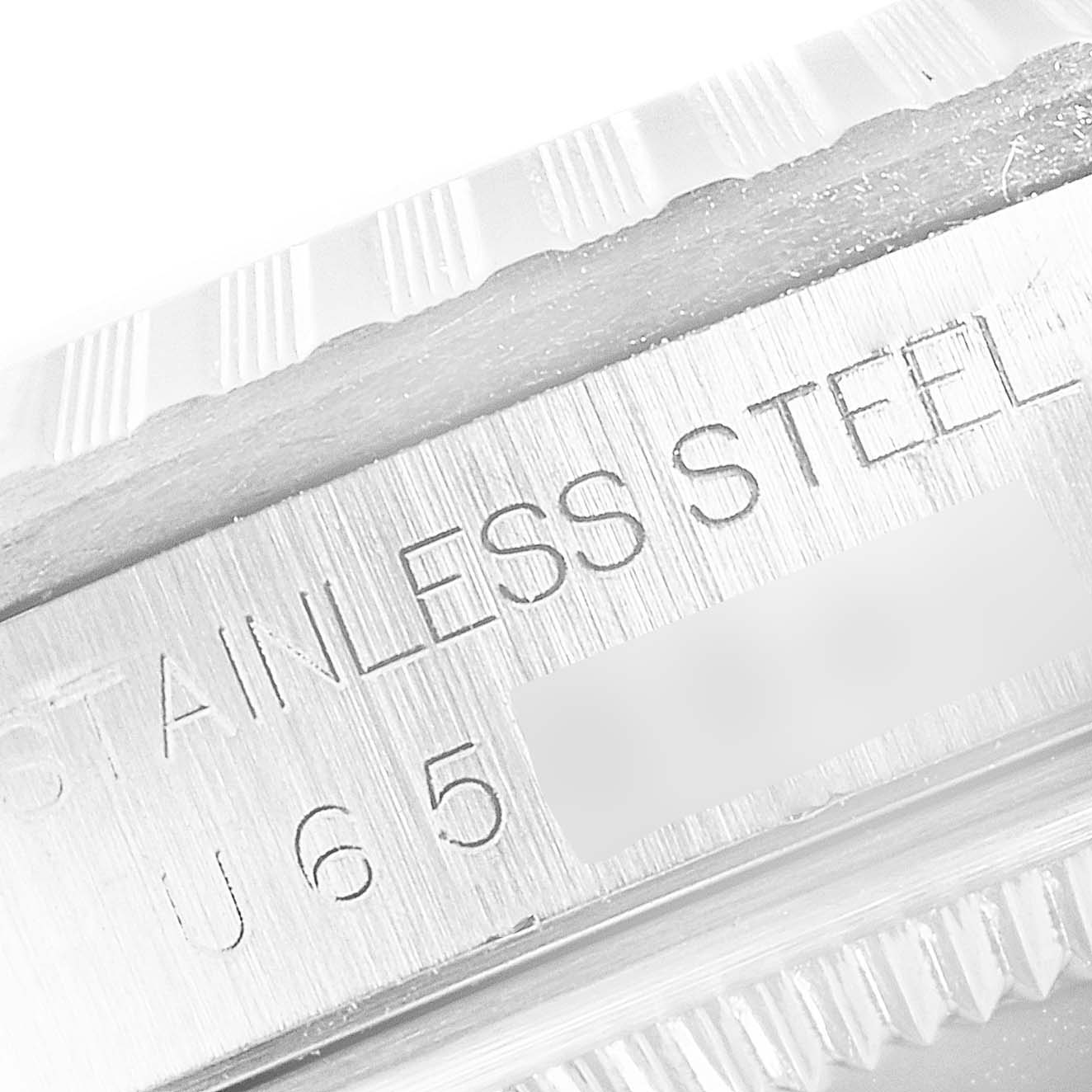 This close-up image shows the inner rim of the case of a Rolex Datejust 16220 Men's Stainless Steel Silver Dial 16220 Men's Stainless Steel Silver Dial watch with stainless steel engraving.