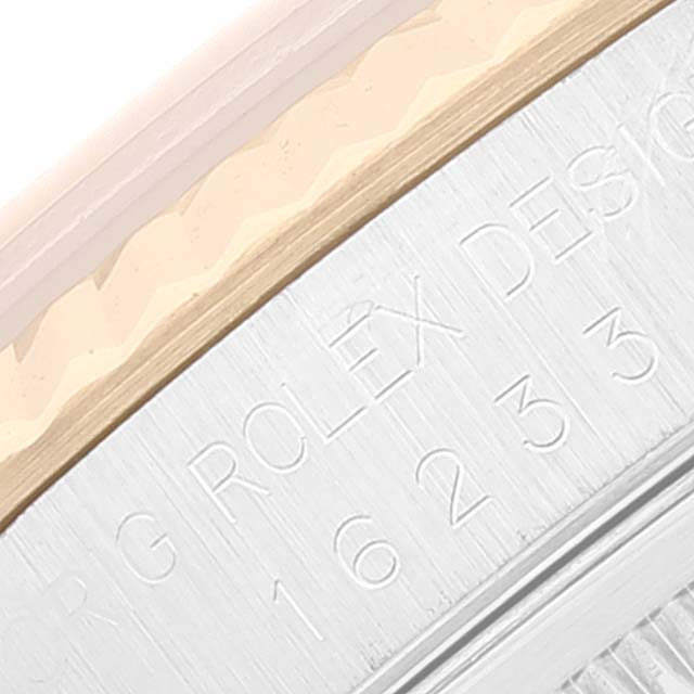 This close-up of the Rolex Datejust 16233 Men's Steel and Gold (two tone) Champagne Dial 16233 Men's Steel and Gold (two tone) Champagne Dial watch focuses on the engraved serial number and part of the band.
