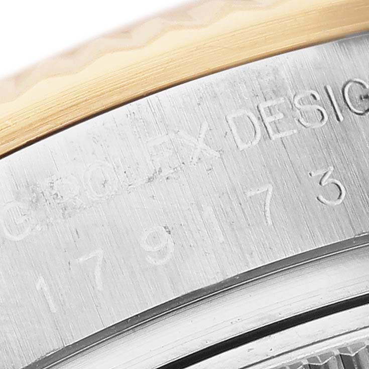The image shows a macro close-up of the casing with "ROLEX DESIGN" engraving on a Datejust model by Rolex.