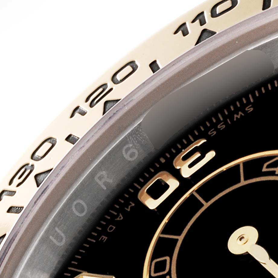 This image shows a close-up of the bezel and part of the dial of a Rolex Daytona 116503 Men
s Steel and Gold (two tone) Black Dial 116503 Men
s Steel and Gold (two tone) Black Dial watch from a top-angle view.