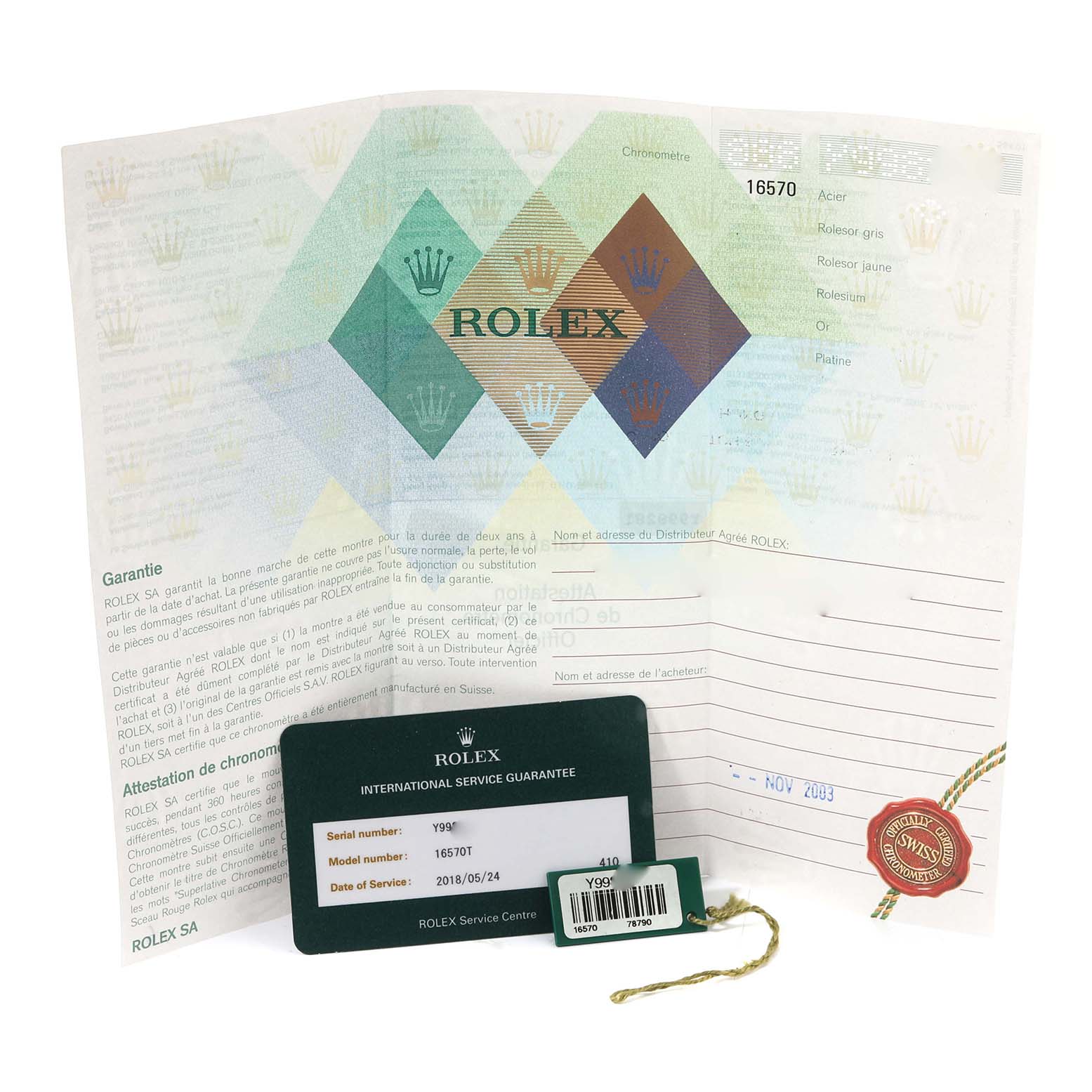 The image shows Rolex Explorer 16570 Men
s Stainless Steel Black Dial 16570 Men
s Stainless Steel Black Dial model documents, tags, and an international service guarantee card from an overhead angle.