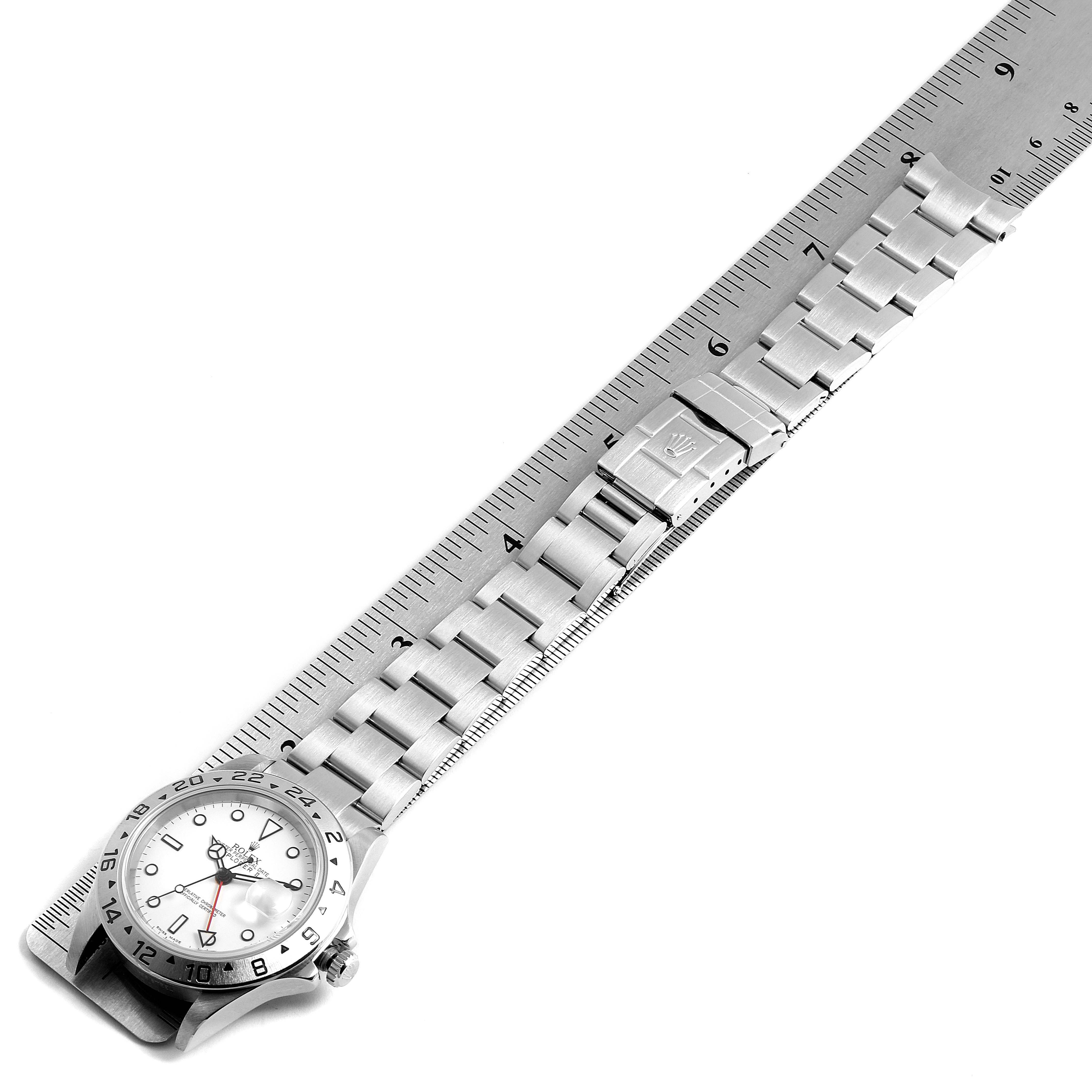 The image shows the Rolex Explorer 16570 Men's Stainless Steel White Dial 16570 Men's Stainless Steel White Dial watch laid flat, displaying its face, bracelet, and clasp, alongside a ruler for size reference.