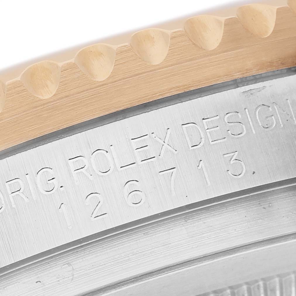 The image shows a close-up of the side of a Rolex GMT-Master 126713GRNR Men's Steel and Gold (two tone) Black Dial, featuring the model number engraving and part of the bezel.