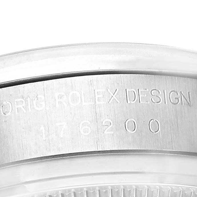 The image shows a close-up of the side of a Rolex Oyster Perpetual 176200 Women's Stainless Steel Black Dial 176200 Women's Stainless Steel Black Dial watch case, featuring the engraved serial number and design engraving.