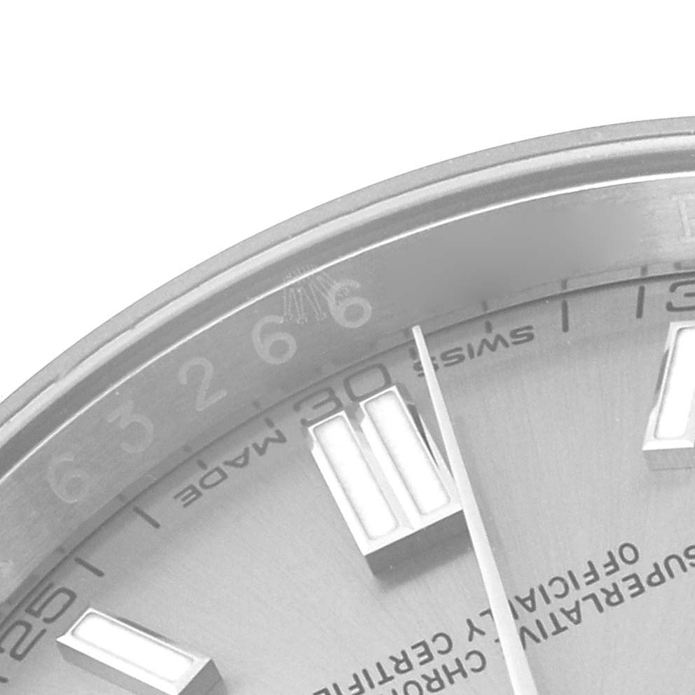 The image shows a close-up of the dial and bezel of a Rolex Oyster Perpetual 116000 Men's Stainless Steel Grey Dial 116000 Men's Stainless Steel Grey Dial watch, highlighting the hour markers, numerals, and part of the text.