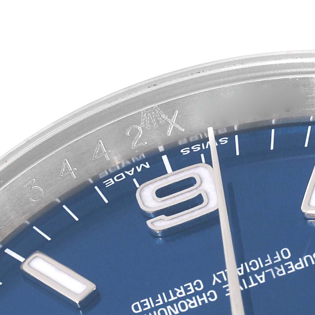 The image shows a close-up of the dial and part of the bezel of a Rolex Oyster Perpetual 116000 Men's Stainless Steel Blue Dial 116000 Men's Stainless Steel Blue Dial watch, displaying the number 9 and "Swiss Made" text.