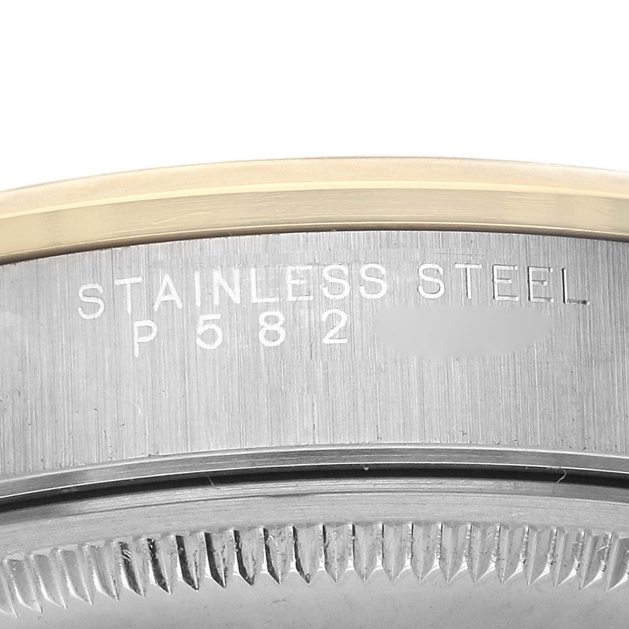 The image shows a close-up of the side engraving on a Rolex Oyster Perpetual 14203 Men's Steel and Gold (two tone) Grey Dial watch, focusing on the text "STAINLESS STEEL P582."