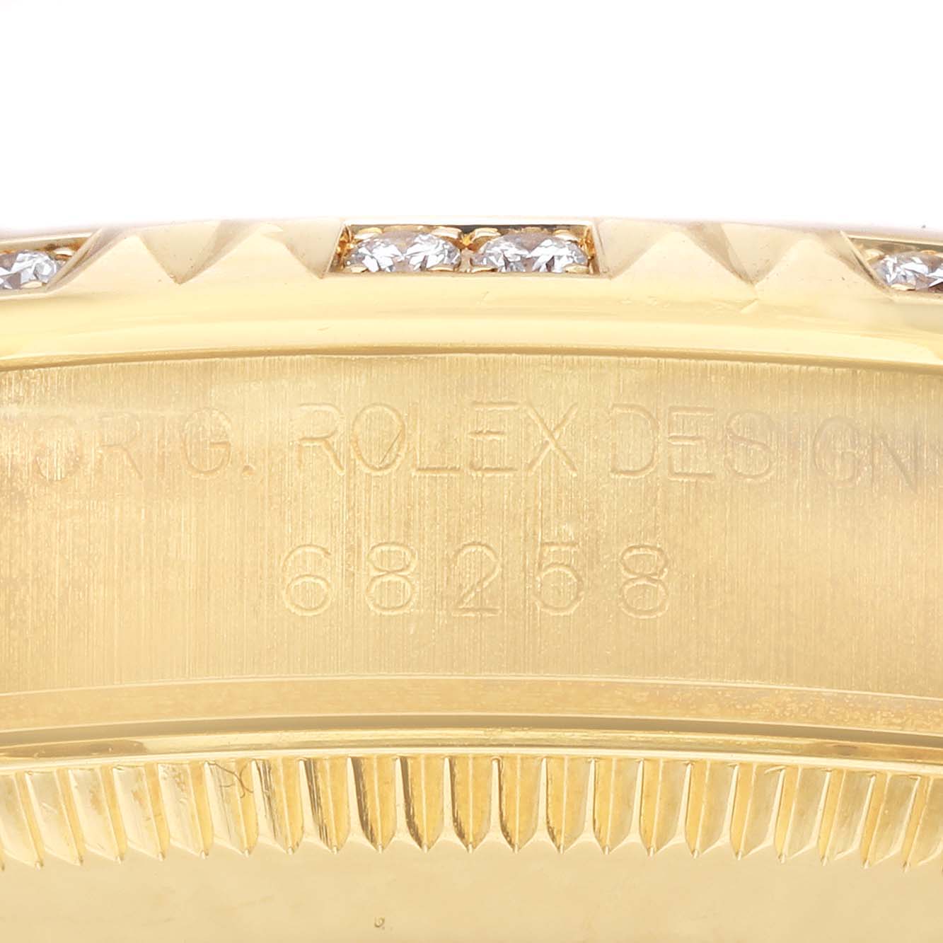 The image shows a close-up of the side of the gold case of a Rolex President 68258 Women's Yellow Gold Champagne Dial 68258 Women's Yellow Gold Champagne Dial model watch, featuring diamond accents and the inscription "Orig. Rolex Design 68258."