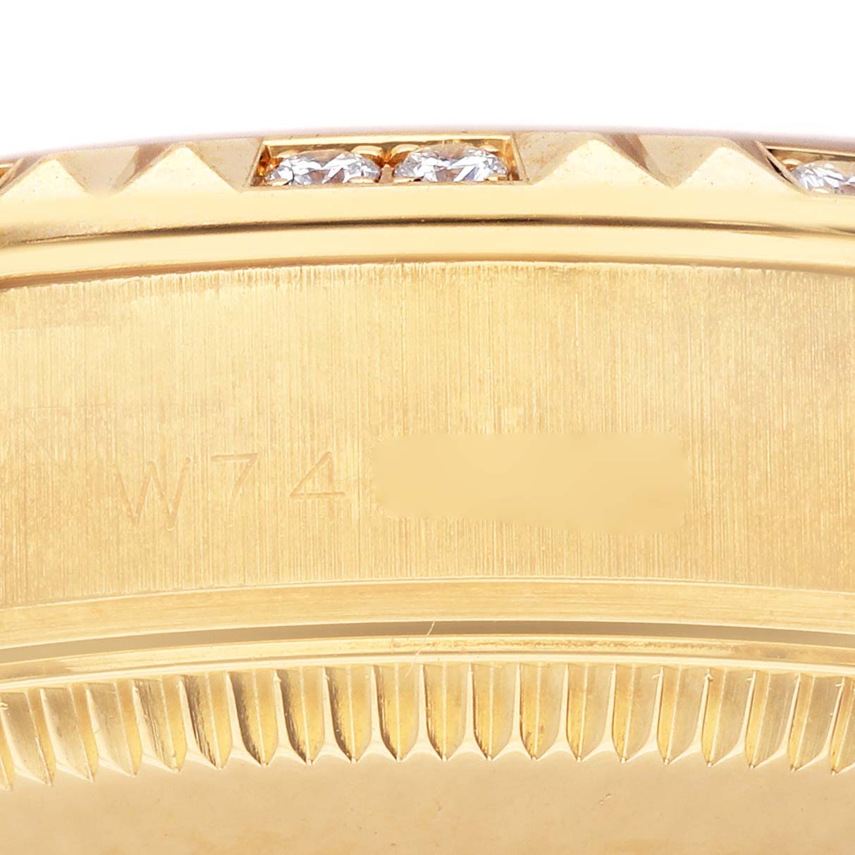 This image shows the engraved side of a Rolex President 68258 Women's Yellow Gold Champagne Dial 68258 Women's Yellow Gold Champagne Dial watch with part of the bezel and serial number visible.