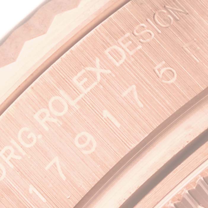 This close-up image shows part of the engraving on the bezel of a Rolex President 179175 Women's Rose Gold Brown Dial 179175 Women's Rose Gold Brown Dial model watch.