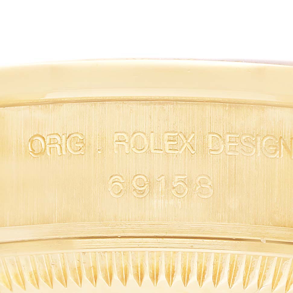 The image shows a close-up of the engraved side of a Rolex President 69158 Women's Yellow Gold Mother of Pearl Dial model, highlighting the design number.