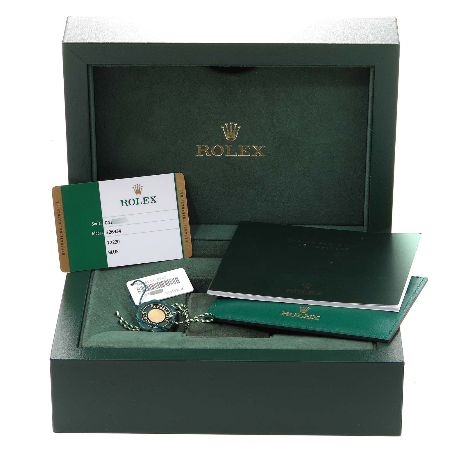 The image shows a green Rolex box with accessories for the Sky-Dweller model, including the guarantee card, tags, and manuals.